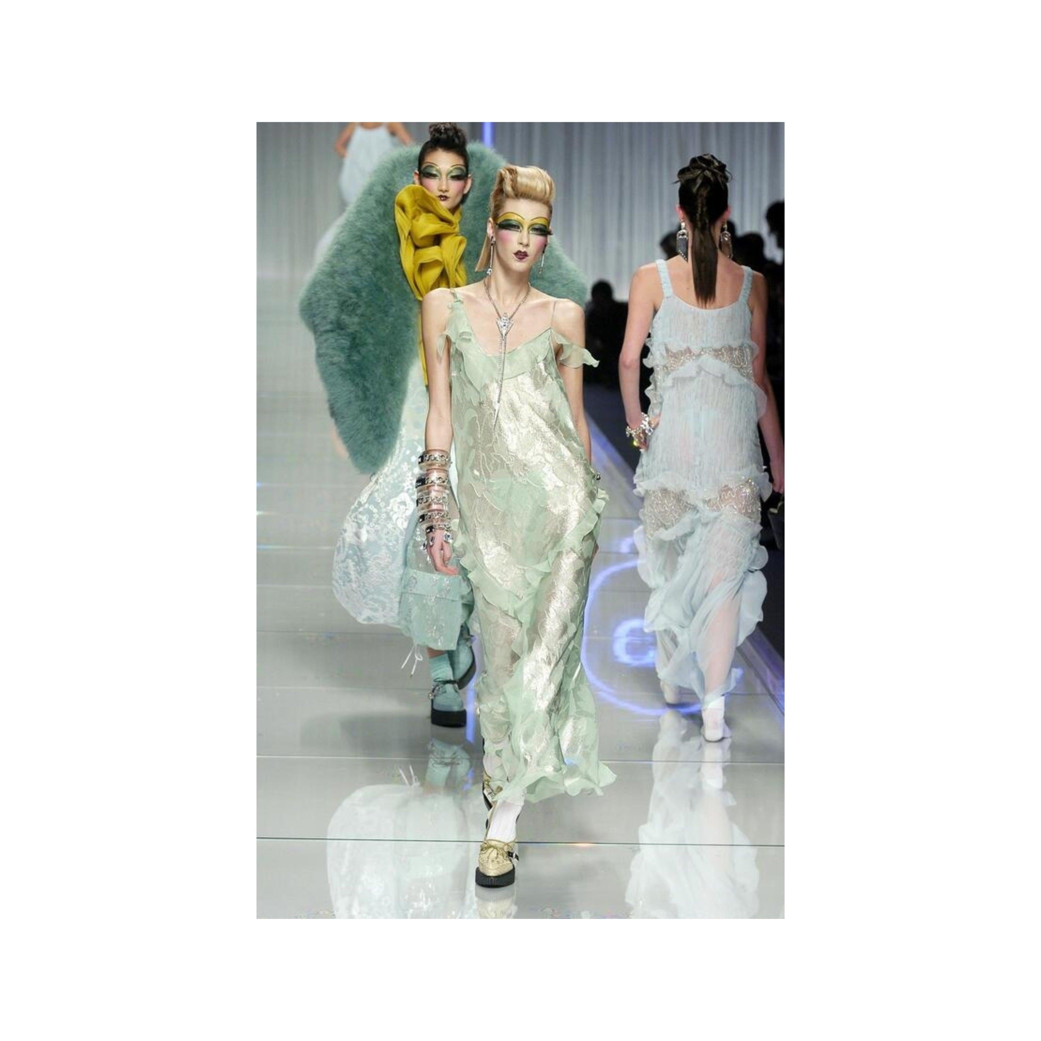 Etereo e delicato: questo raro abito di John Galliano for Christian Dior è caratterizzato da un morbido chiffon di seta beige chiaro con romantici volant e una femminile scollatura a cappuccio. Le linee di volant diagonali e vorticose aggiungono un
