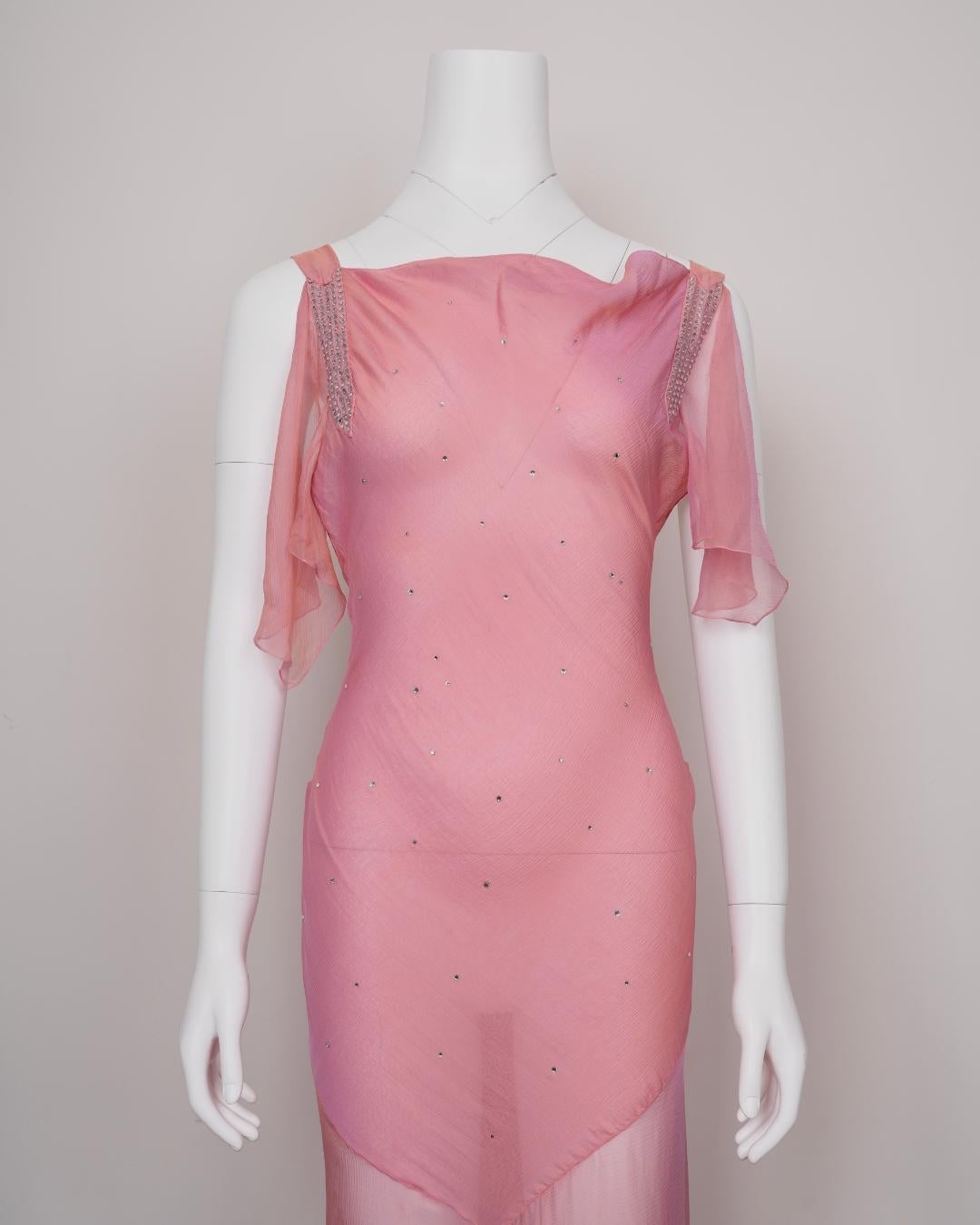 Dieses schräg geschnittene Abendkleid ist ein leuchtendes Beispiel für John Gallianos romantische Vision für Dior in den frühen 2000er-Jahren. Es wurde aus rosé- und goldfarbenem Changeant-Chiffon gefertigt - einem Stoff, dessen Farbton sich bei