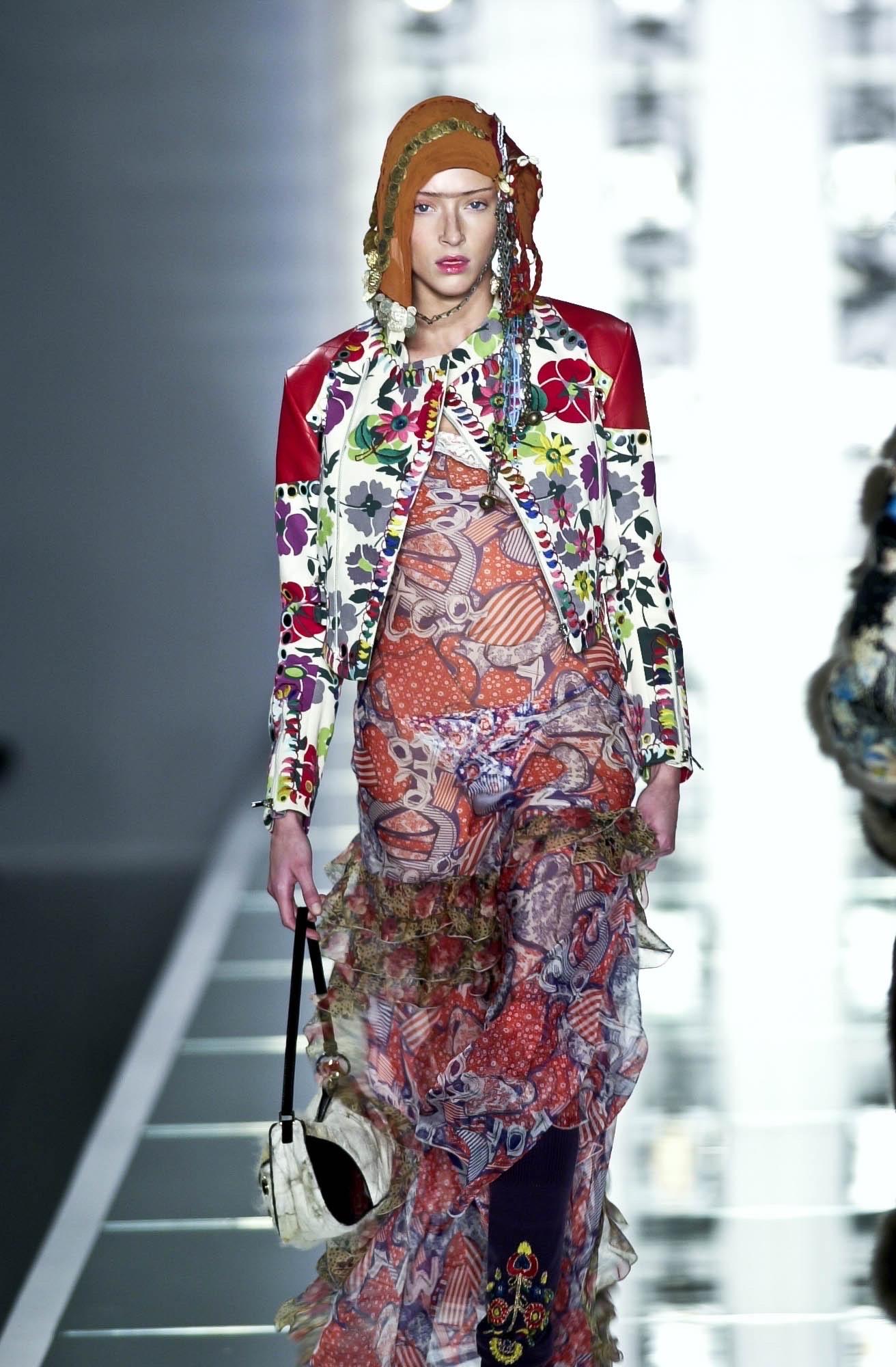 Christian Dior by John Galliano for Christian Dior Autunno/Inverno 2001, abito in chiffon di seta stampato lungo fino a terra con volant a strati. 

Collo in pizzo di cotone, alamari in ottone CD e bottoni classici in tessuto. 

Contrassegnato dalla