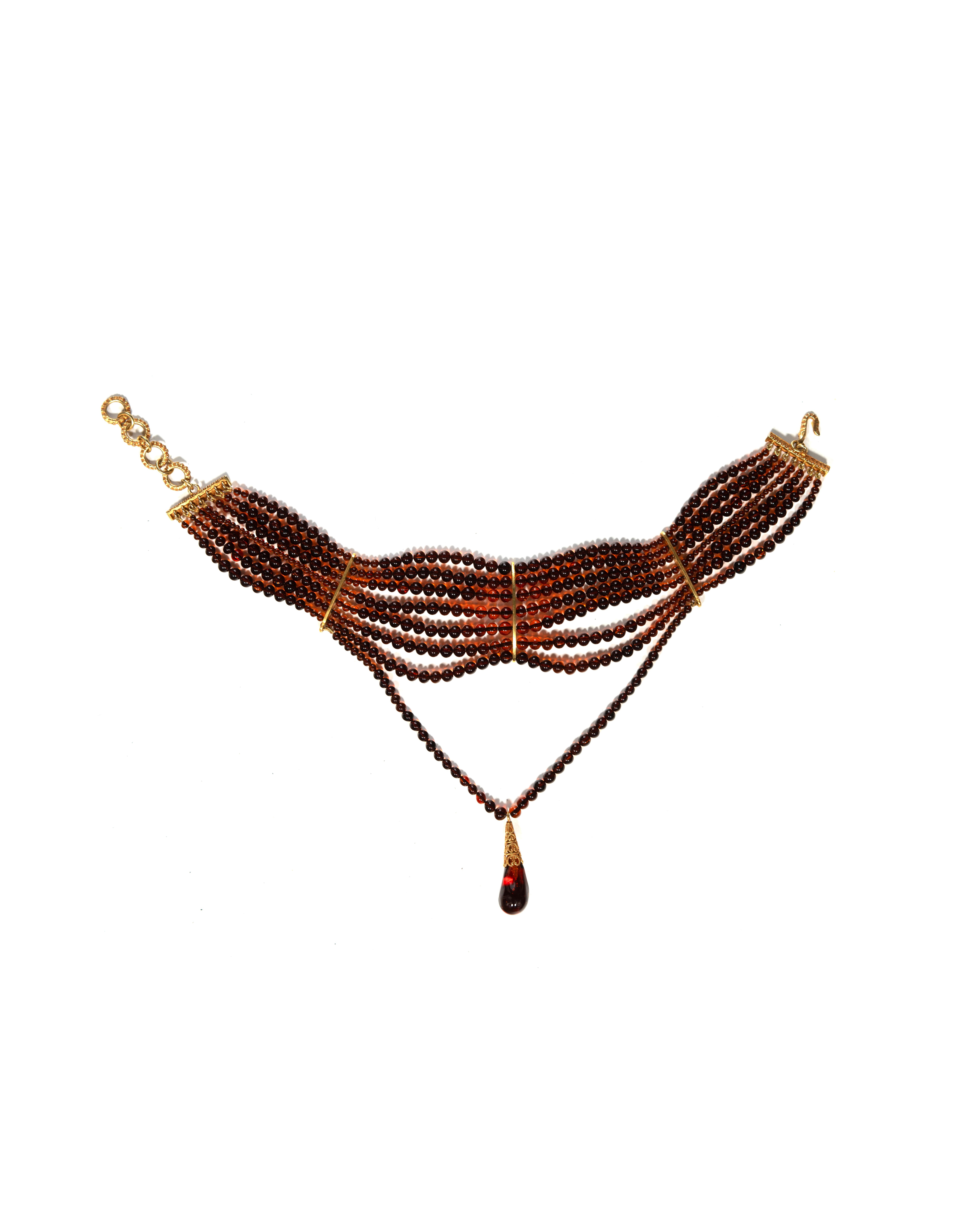 ▪ Archival Christian Dior 'Masai' Choker Necklace
▪ Creative Director: John Galliano
▪ c. 1998 
▪ Sold by One of a Kind Archive
▪ Embellished with 7 strands of exquisite amber glass beads
▪ The centerpiece boasts an additional hanging strand adorned