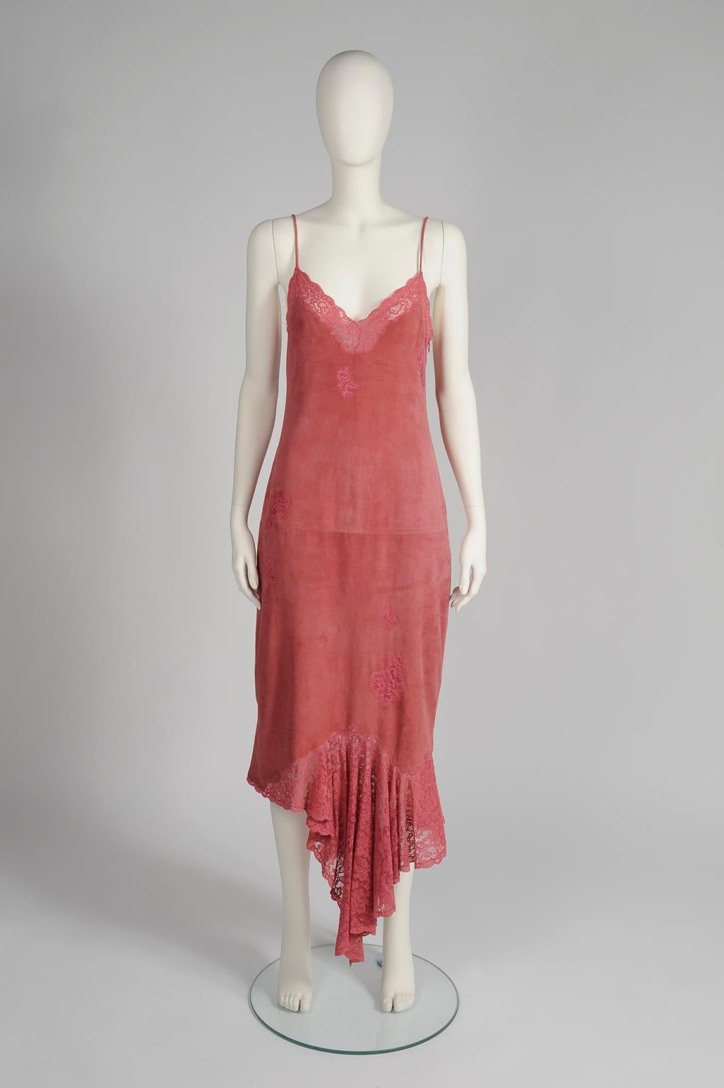 This gown by John Galliano for Dior is the proof that glamour and ease can go hand in hand. Cut from super soft antique rose suede, the dress is embellished with color matching lace. The deep V-neckline, spaghetti straps and low-cut back create the