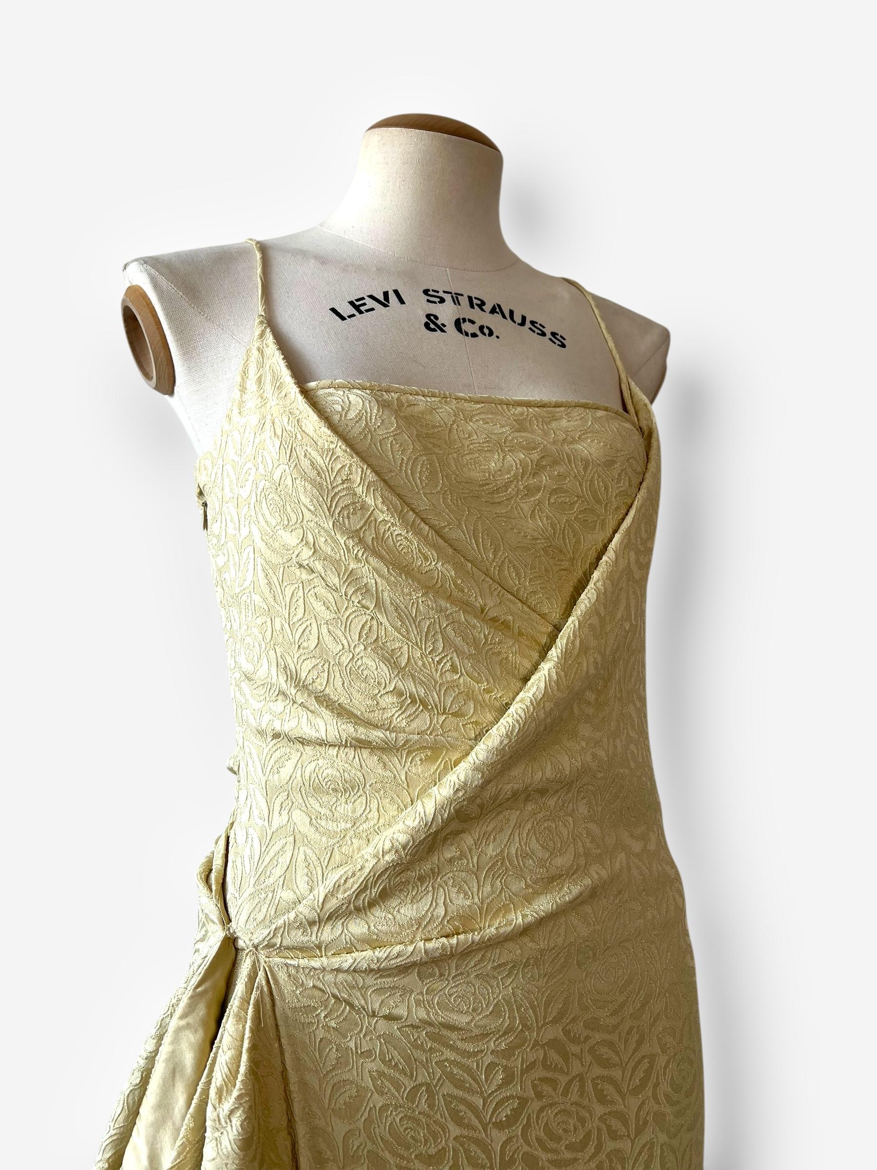 Questo raro abito Dior dell'iconica collezione Autunno/Inverno 1998 di John Galliano è realizzato in lussuoso broccato di seta color oro pallido con un intricato motivo botanico. Disegnato con l'inconfondibile silhouette a taglio sbieco di Galliano,