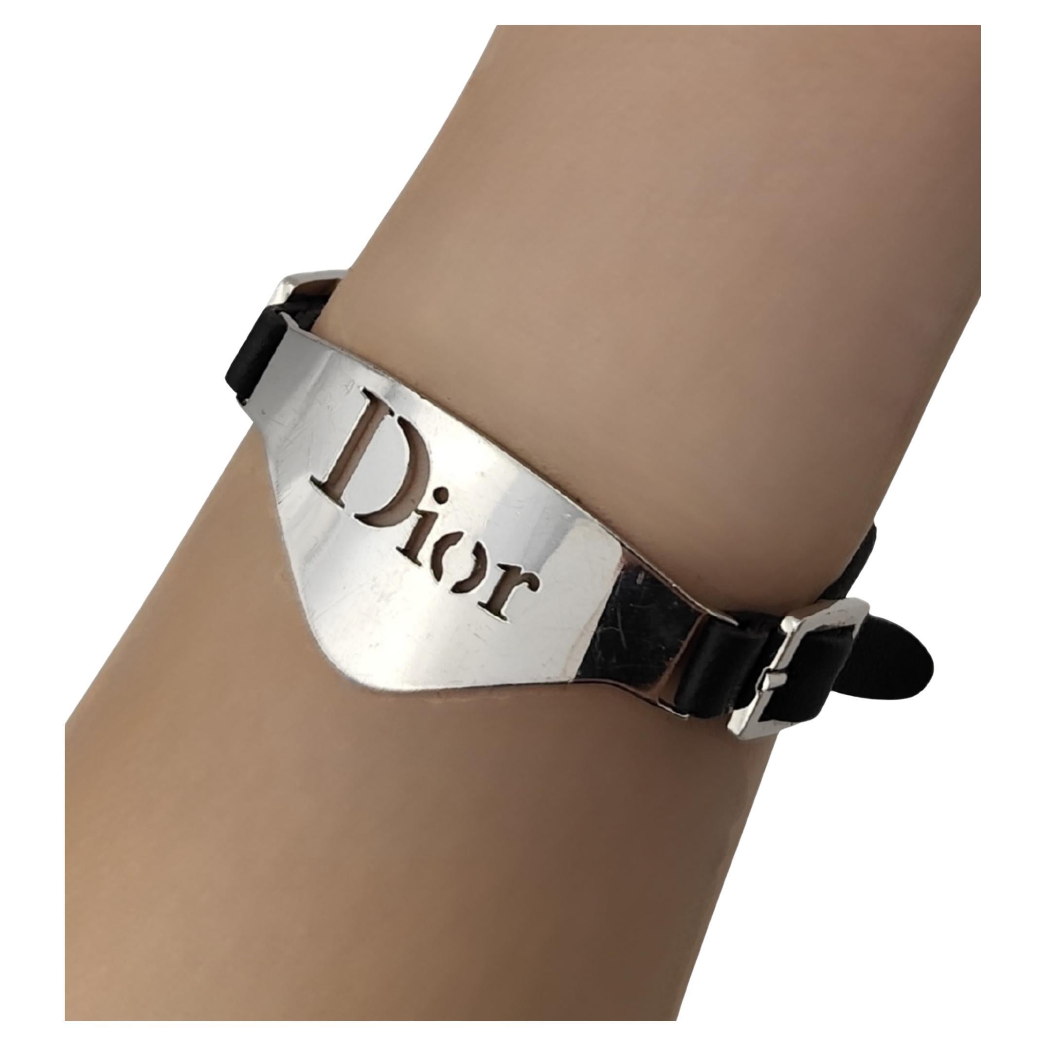 Christian Dior by John Galliano bracelet
Silver metal logo plate
Black leather straps
Adjustable clasp closure

Measurements:
length 18-24 cm - 7-9.5 in
height 2.5 cm - 1 in

Very good condition
Minor signs of use
