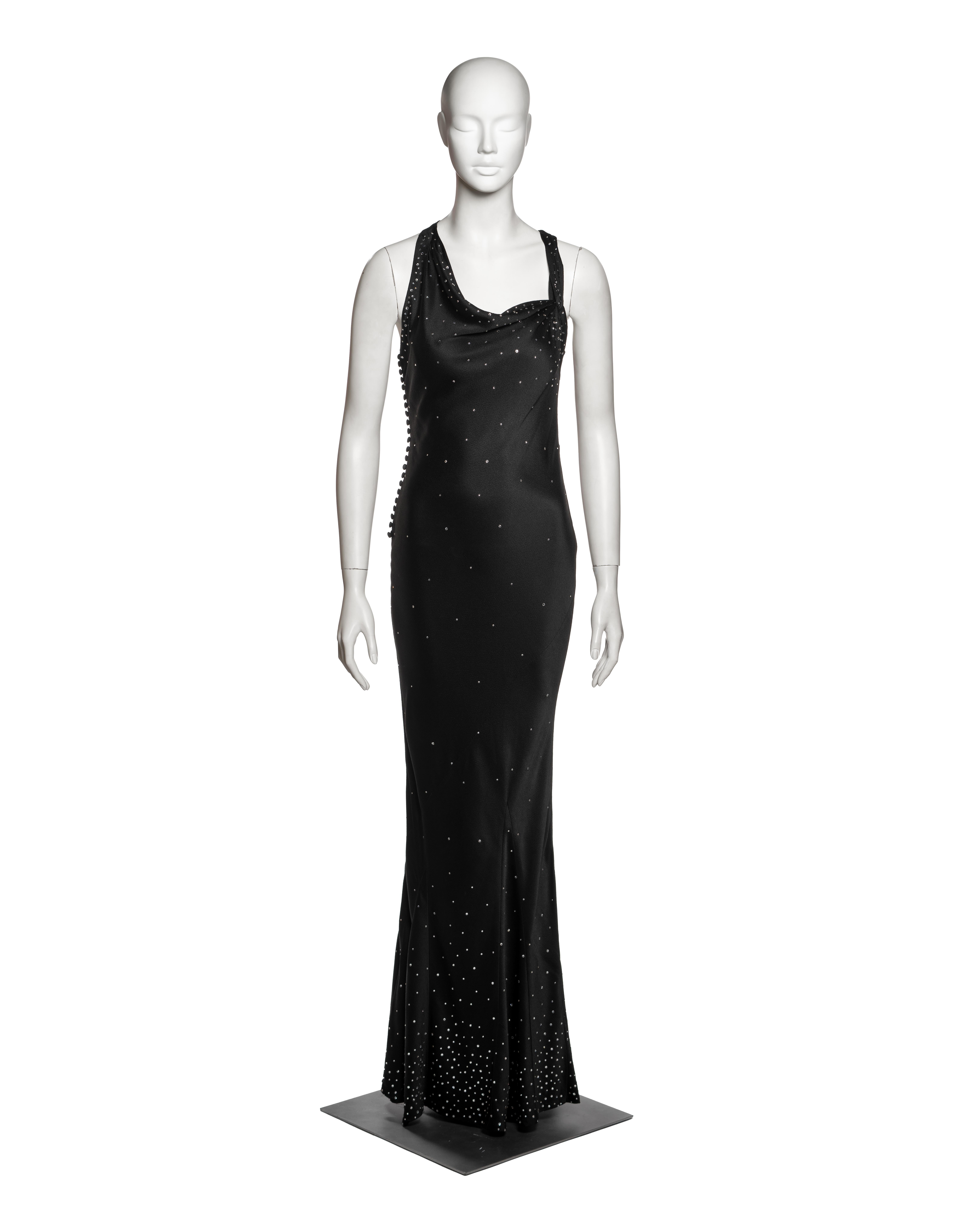 Robe du soir sans manches en satin martelé noir, Christian Dior by John Galliano. Coupe en biais près du corps avec un ourlet subtilement évasé. Le devant présente un décolleté drapé soutenu par de larges bretelles qui émergent du bord de