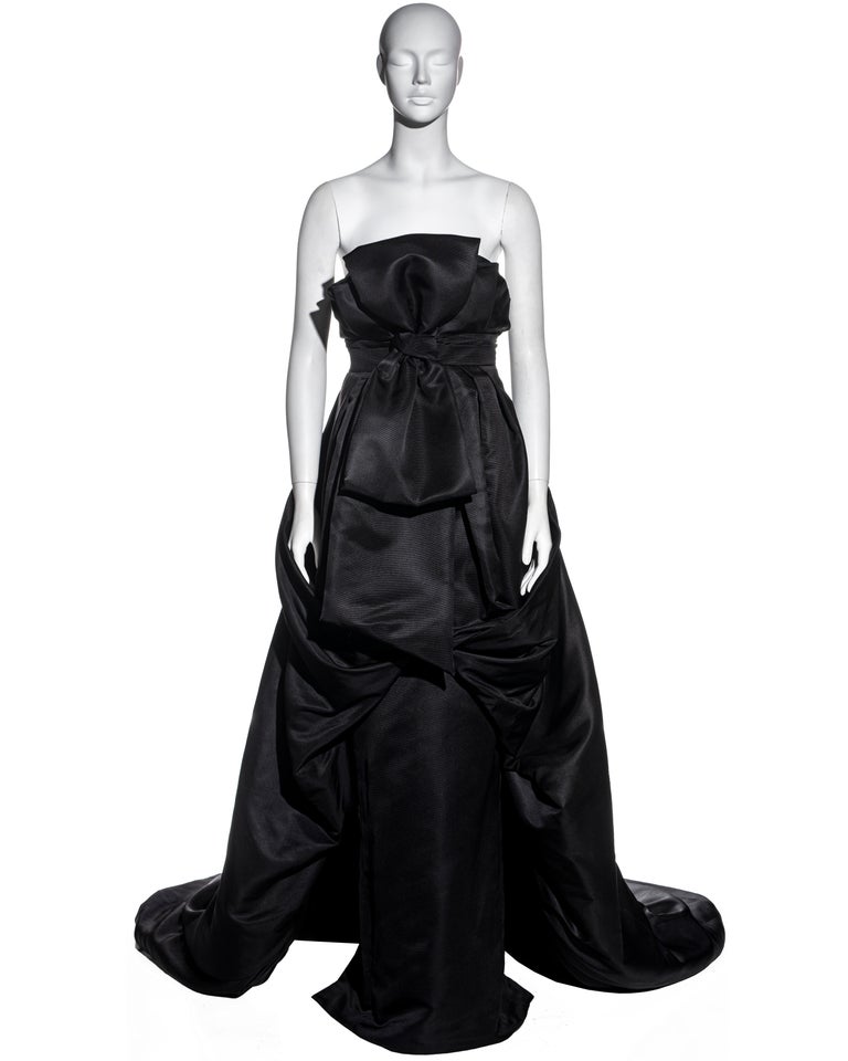 ▪ Christian Dior black silk faille strapless evening gown
▪ Designed by John Galliano
▪ Built-in boned corset with underwired bra 
▪ Oversized draped bow
▪ Narrow floor-length skirt with draped trained puff-ball overskirt
▪ Heavy-weight 
▪ FR 38 -