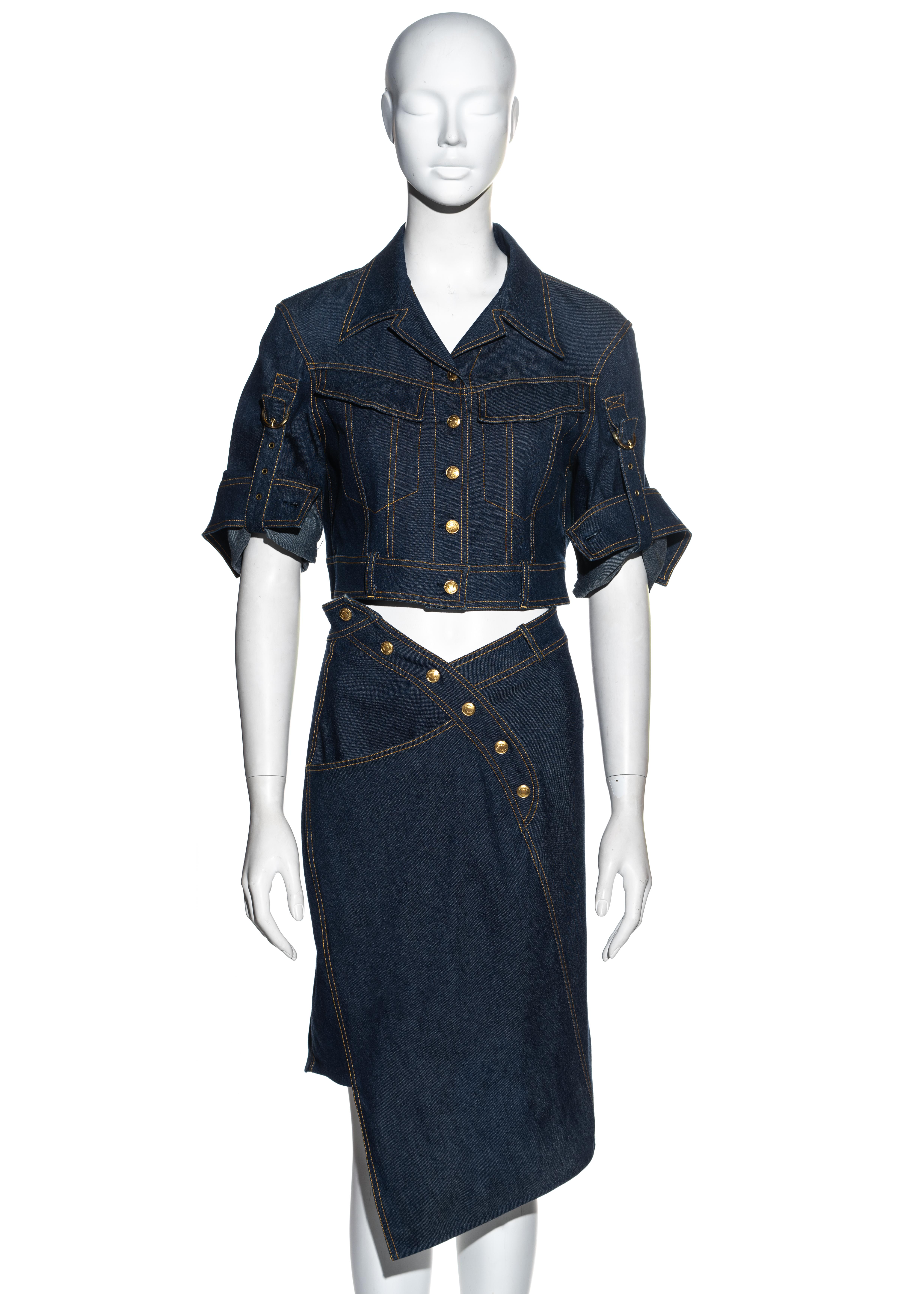 ▪ Christian Dior indigo blue denim jacket and skirt 2 piece set
▪ Designed by John Galliano
▪ Cropped denim jacket 
▪ Bias cut skirt with asymmetric waistline and hemline 
▪ Gold logo signed rivet buttons
▪ Turn-up sleeves with gold buckle