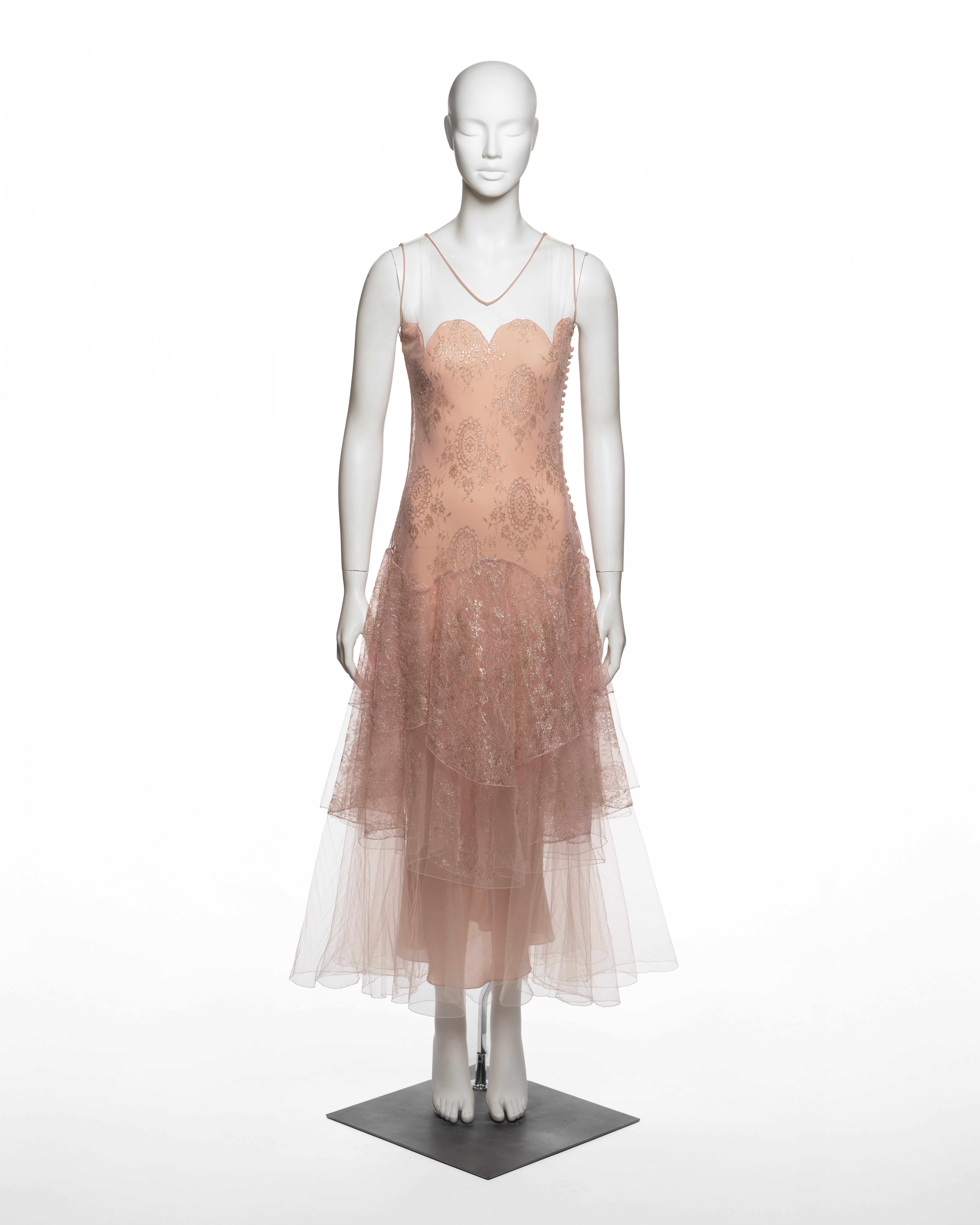 Evening dress by John Galliano for Christian Dior from the Fall-Winter 2002 collection, composed of blush pink nylon tulle with an integrated silk slip, featuring metallic gold flocked lace motifs in a symmetrical medallion arrangement. The fitted