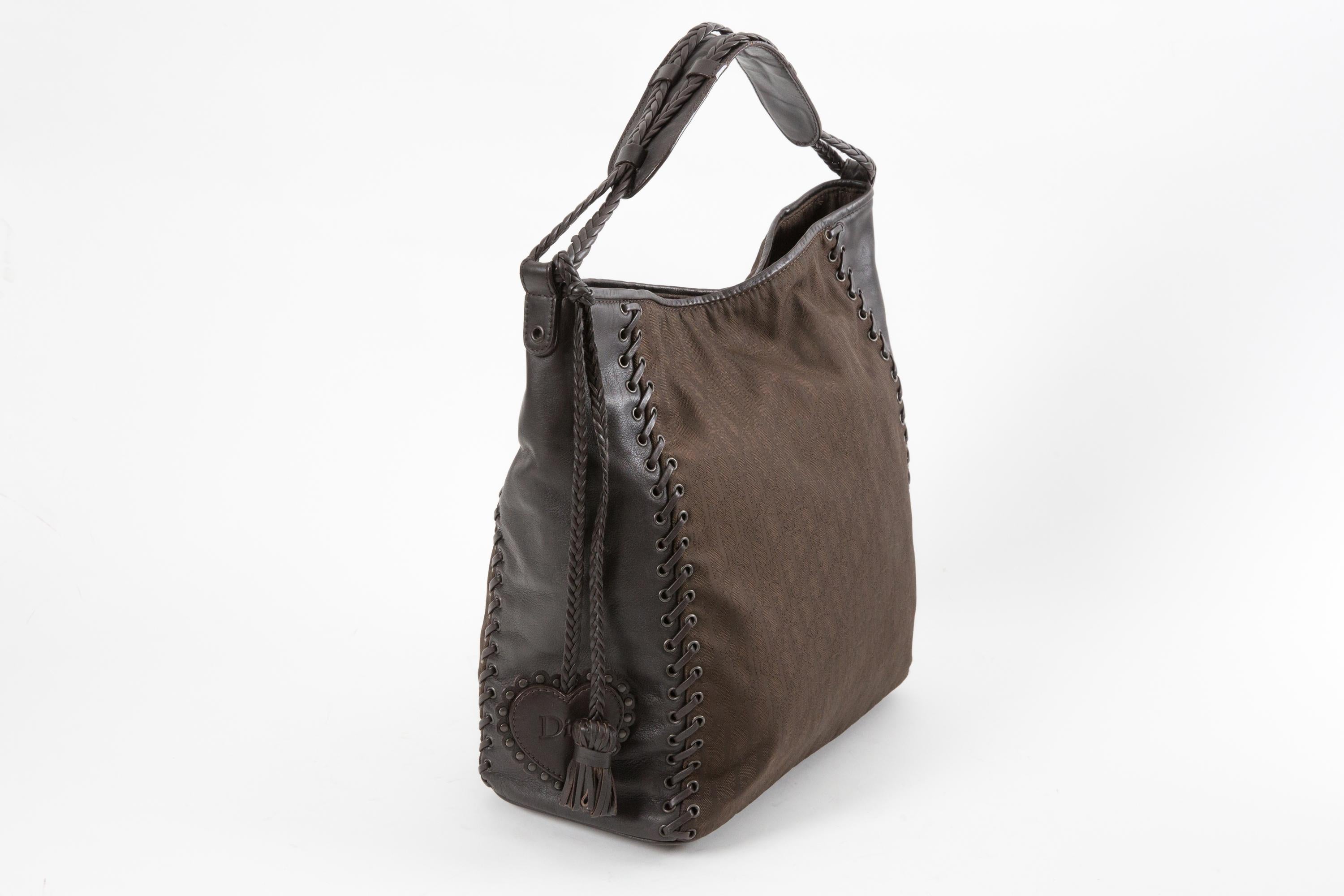 Christian Dior by John Galliano Brown “Heart Charm Ethnic” tote bag featuring a signature “Trotter” monogram pattern, brown leather details, leather lace-up detailing, a leather heart charm, magnetic fastening, main compartment, internal