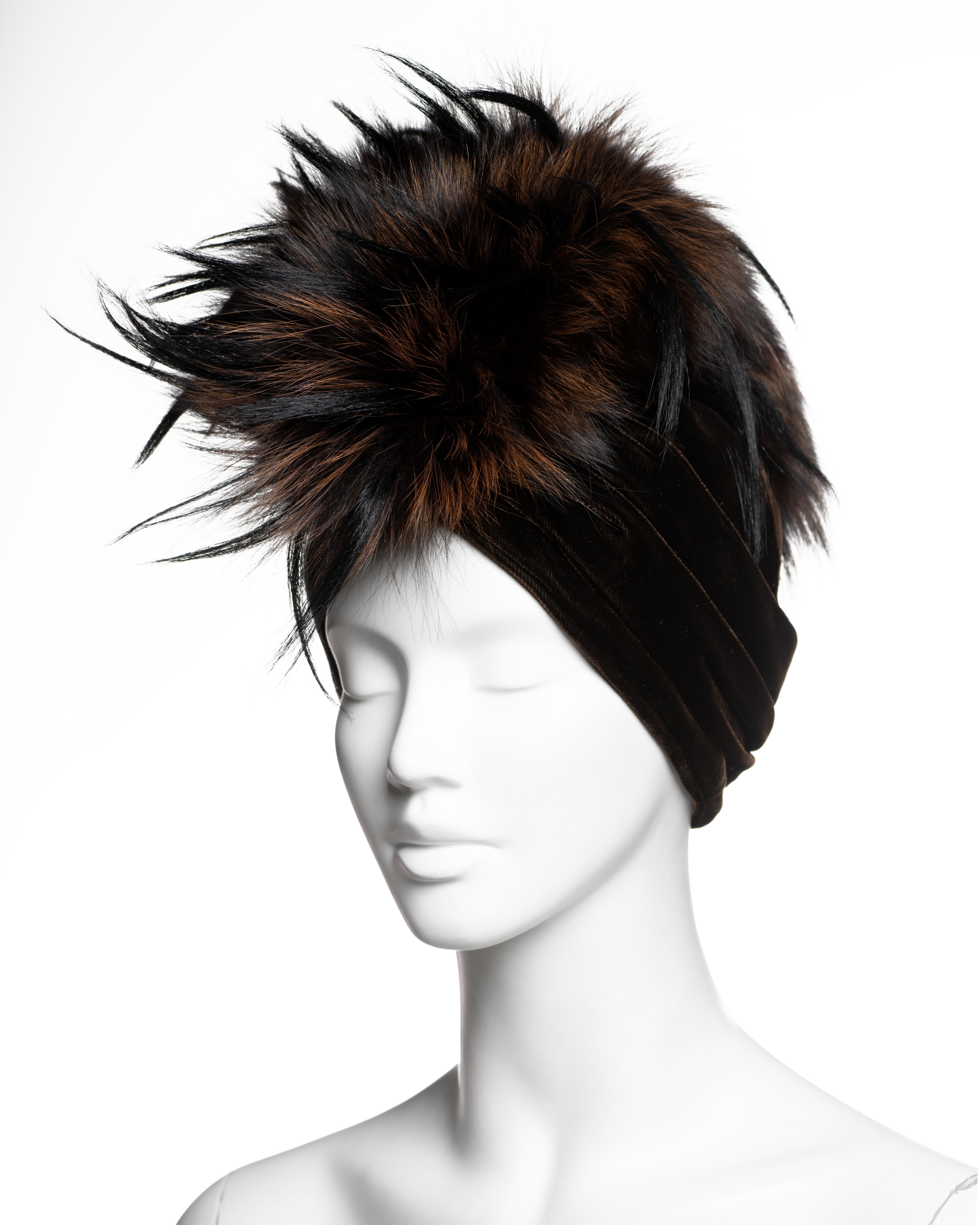 Copricapo in stile turbante di John Galliano for Christian Dior della collezione A. Winter 2007, realizzato in velluto di seta color cioccolato intenso, drappeggiato in sbieco e increspato orizzontalmente per formare una fascia aderente. La corona è