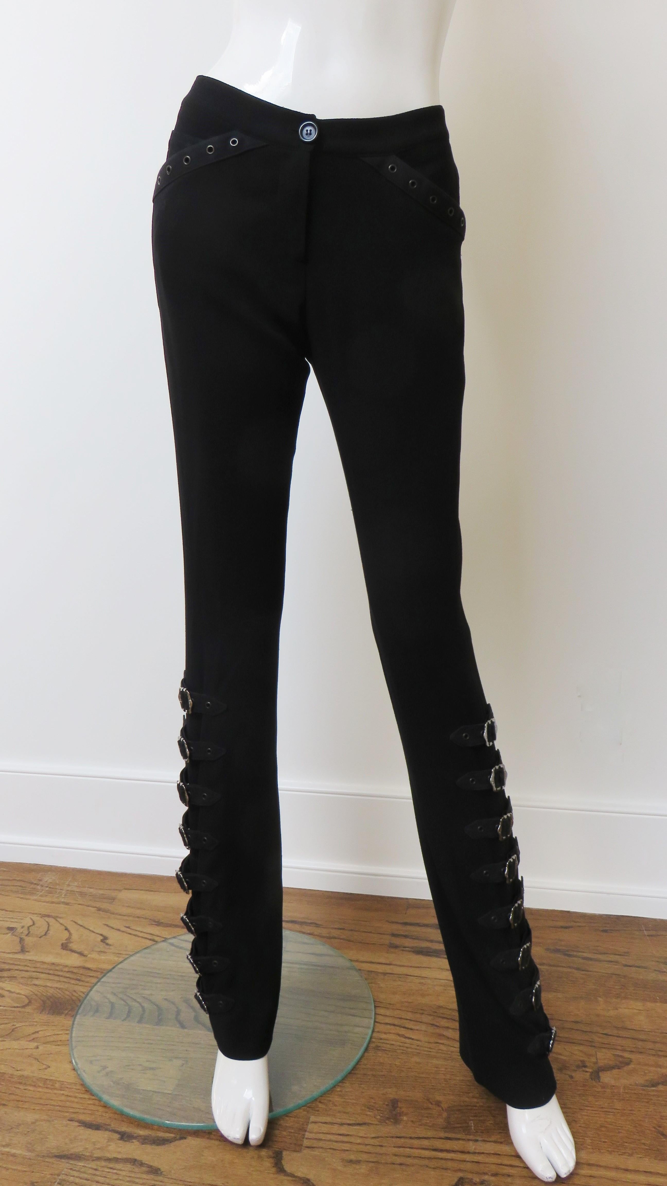 Fabulous light weight black wool pants by John Galliano for Christian Dior.  They have a button front waistband and zipper closing, grommet trimmed front pockets and iconic Dior inscribed silver buckles and straps along the side of each straight leg