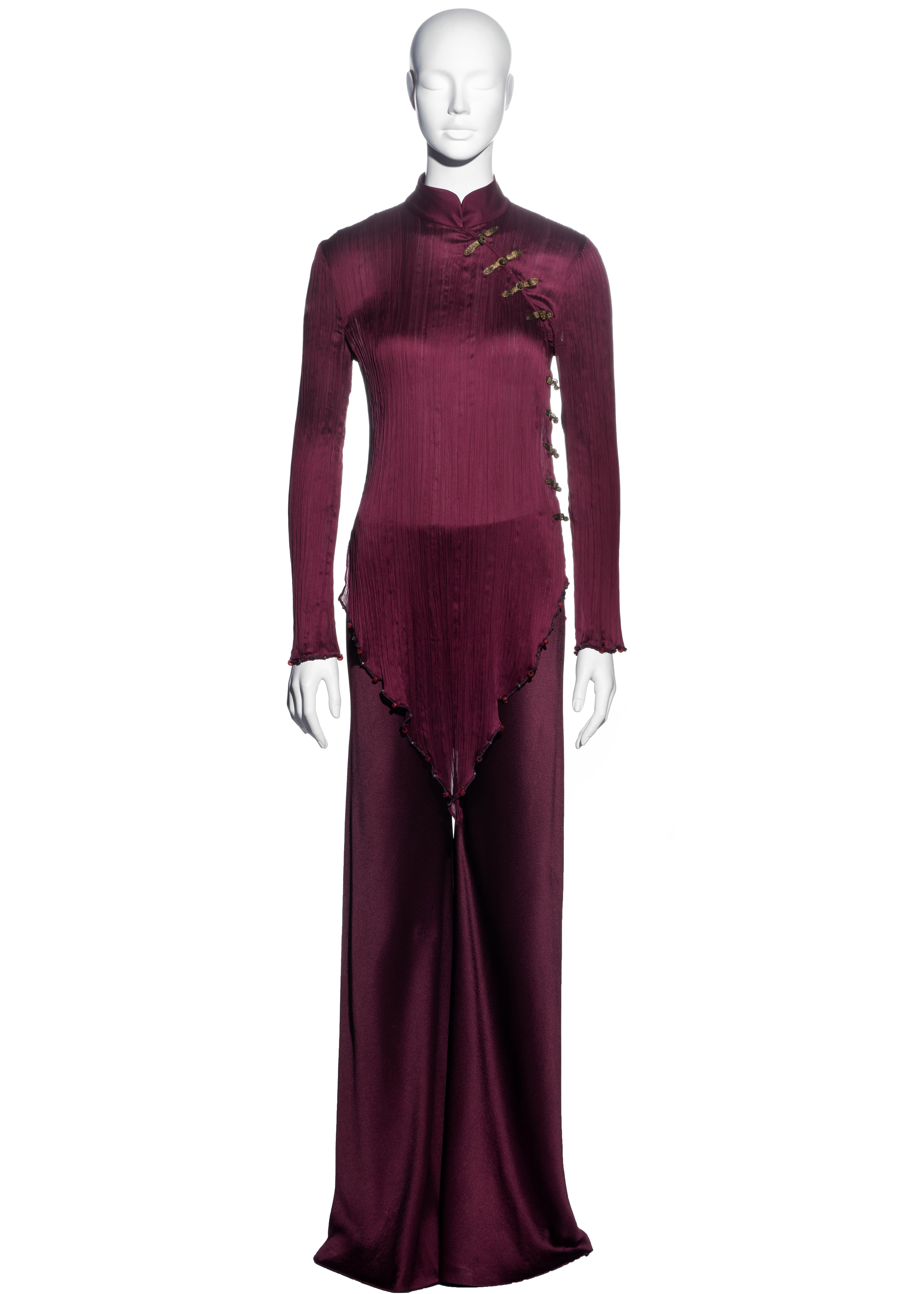 ▪ Christian Dior burgundy pleated pant suit
▪ Designed by John Galliano 
▪ Mandarin collar  
▪ Cheongsam style  
▪ Mariano Fortuny style pleats  
▪ Gold lamé frog fastenings  
▪ Beaded rope trim
▪ Wide leg pants 
▪ Pants: FR 40 - UK 12 - US 8
▪