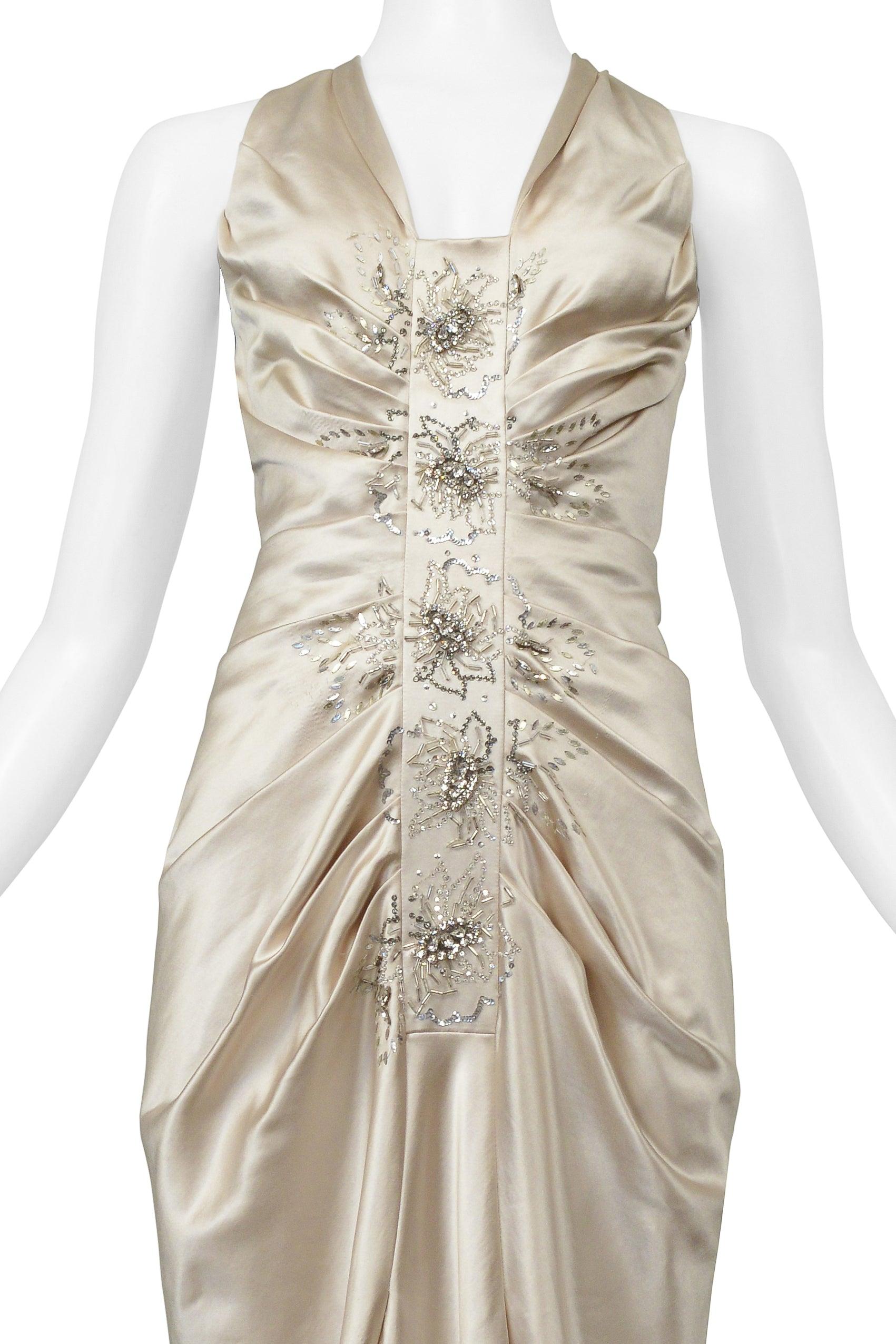 Resurrection is excited to offer a vintage Christian Dior by John Galliano off-white champagne satin evening gown featuring dramatic side pleating, delicate crystal beading down the center front placket, a center back zipper, and floor length.

*