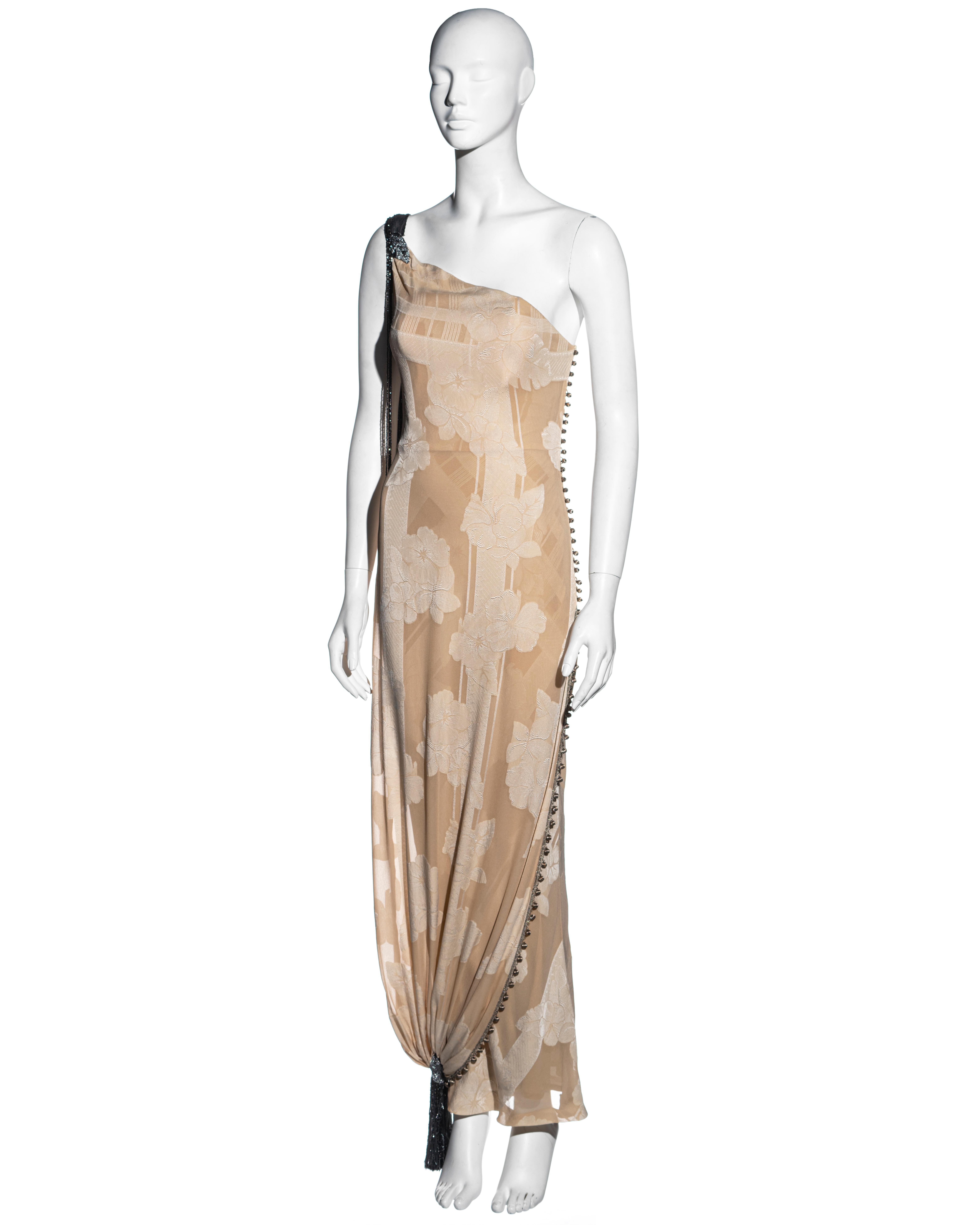 ▪ Vestido de noche de un hombro con brocado de seda crema Christian Dior
▪ Diseñado por John Galliano 
▪ Corsé incorporado 
▪ Doble capa 
▪ Sobrefalda drapeada 
▪ Borlas de cuentas e hilo de seda en el hombro y el tobillo 
▪ Botones de tela tejida