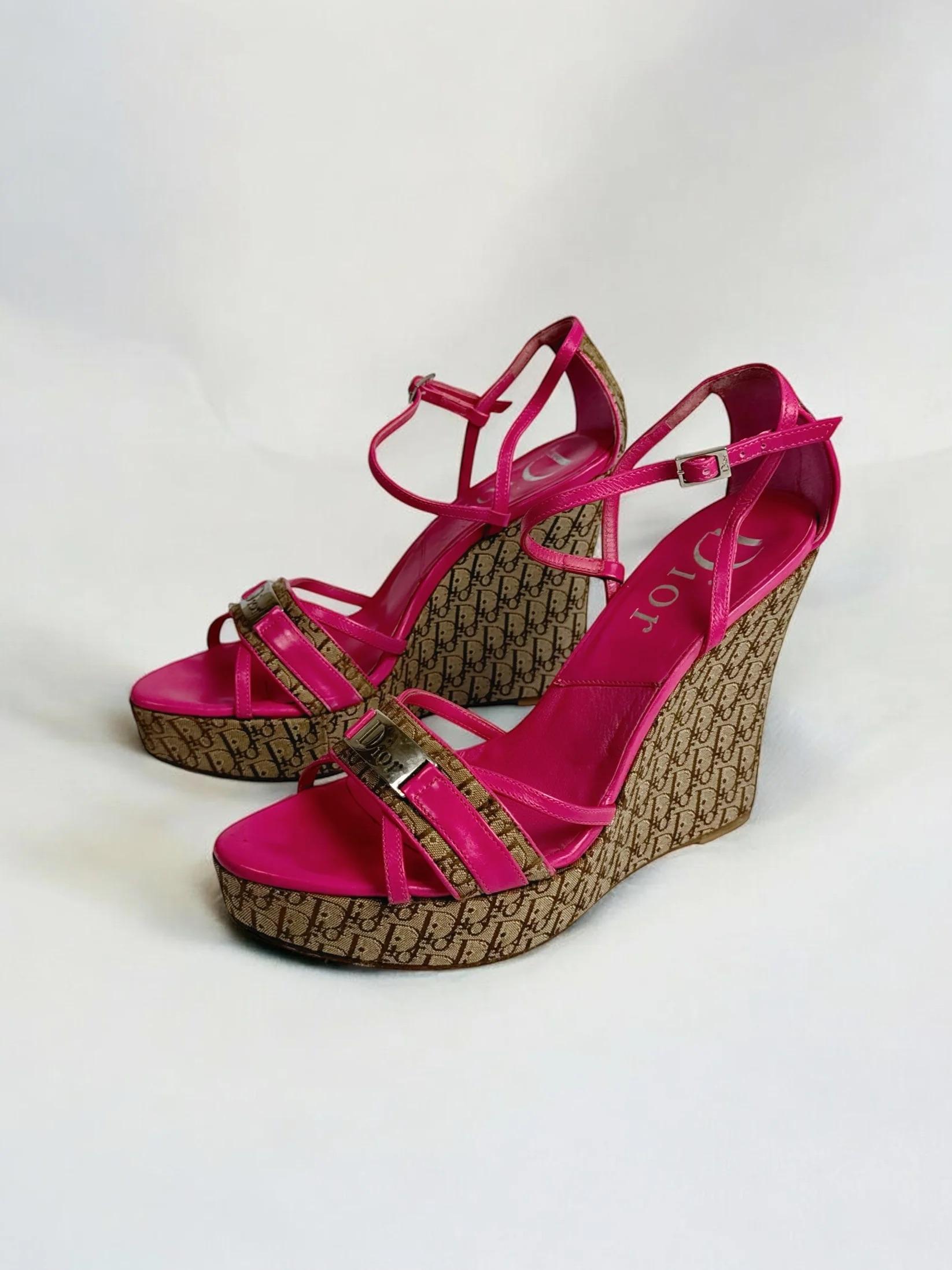 Christian Dior by John Galliano Diorissimo wedge heel sandals, early 2000s
Hot pink leather with brown monogram fabric, accented by a silver “Dior” plaque on both shoes
With original packaging
Good overall condition with some wear to fabric,