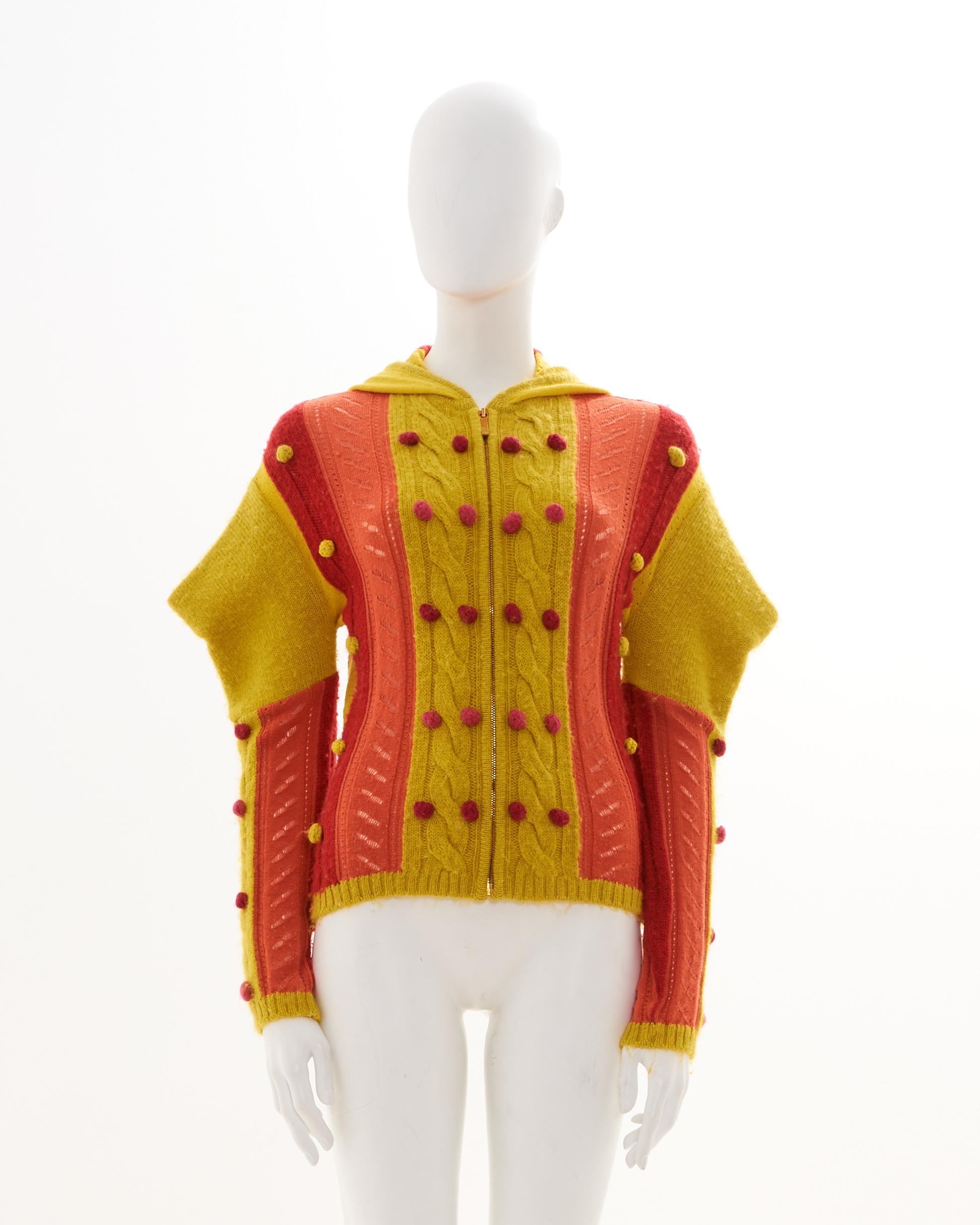 - Designed by John Galliano
- Sold by Skof.Archive
- Fall-Winter 2002 
- Multicolor alpaca knitted hooded cardigan 
- Frontal silver zipper closure 
- Pointed shoulders 
- Little pompom all-over 
- Made in France 
- Size: FR 38 - EN 42 - UK 10 - US
