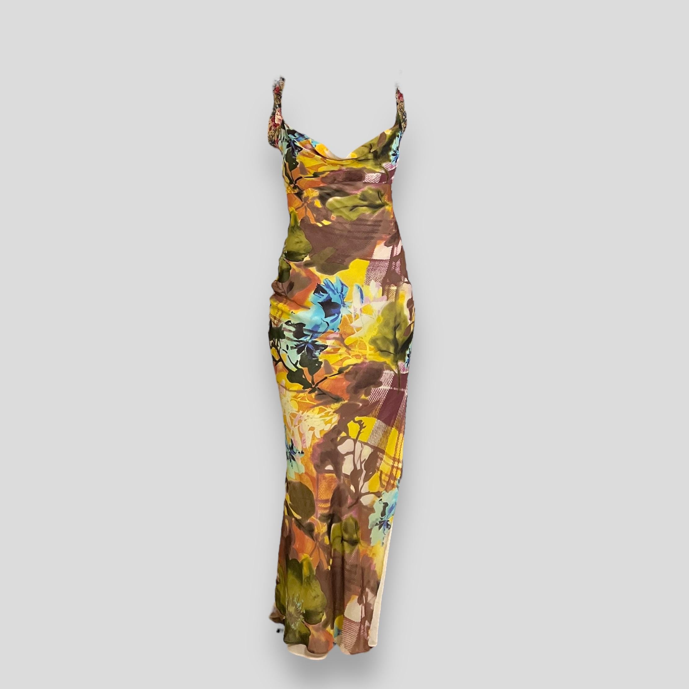 This stunning full-on maxi dress by Christian Dior features a vibrant multi-color floral print on luxurious 100% silk. Designed with a high slit at the side, this dress is fully lined in silk, ensuring a comfortable and elegant fit. It is marked as