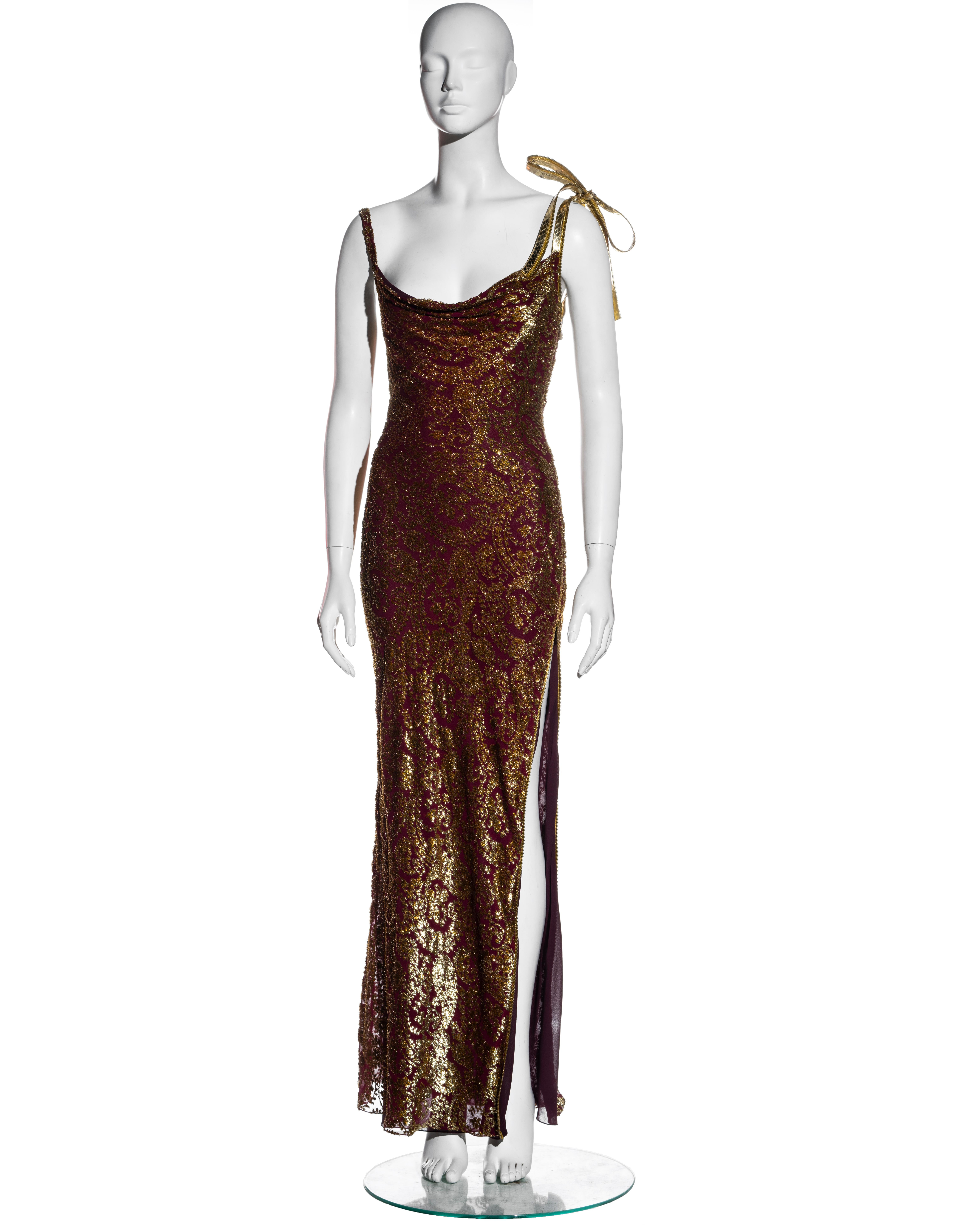▪ Christian Dior gold and burgundy lurex silk devoré evening dress
▪ Designed by John Galliano
▪ Cowl neckline 
▪ Metallic gold snakeskin shoulder strap with a bow
▪ Double-ended zipper at side seam which can be opened to create a leg slit 
▪ Silk