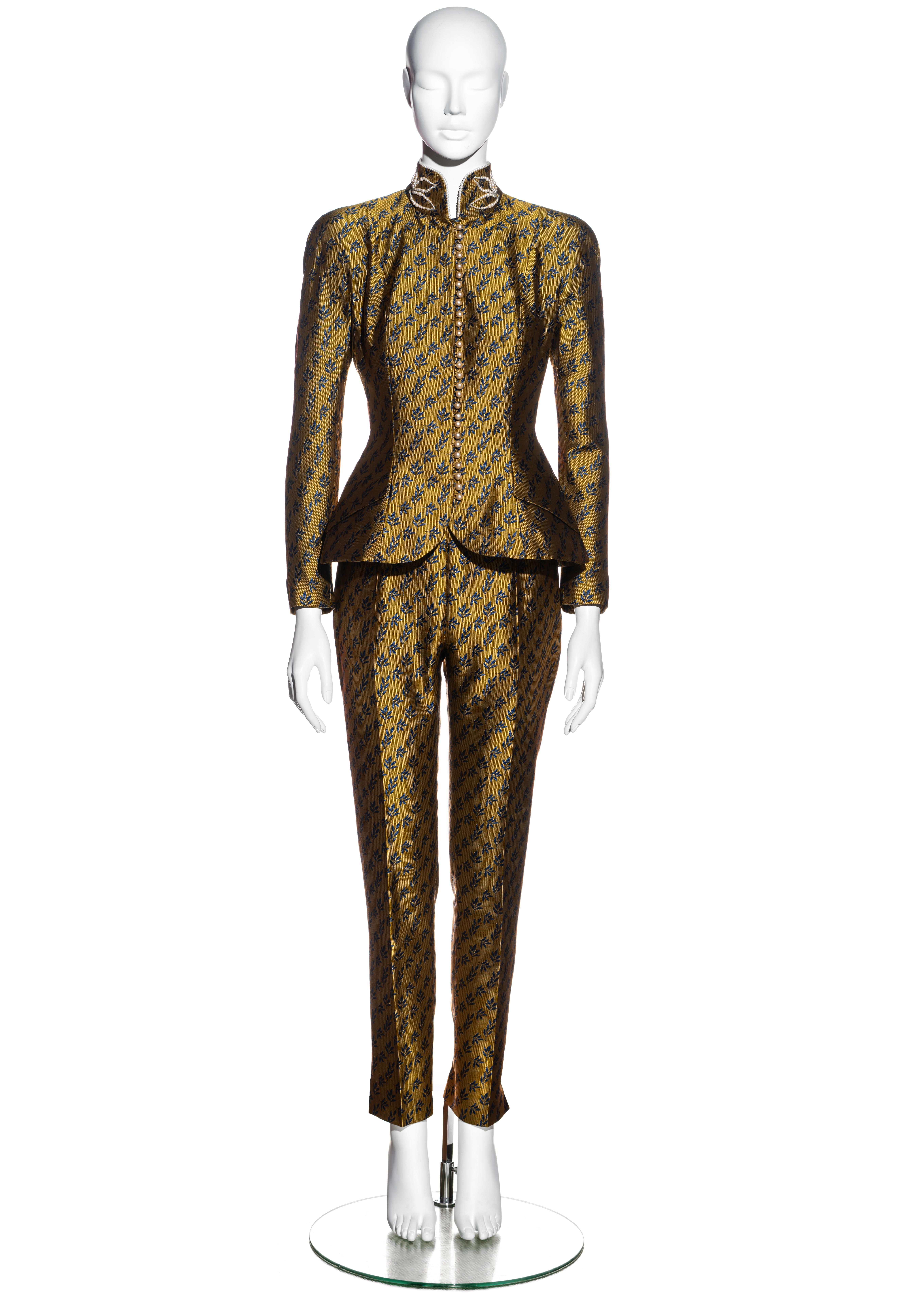 ▪ Christian Dior gold satin jacquard fitted evening pant suit  
▪ Designed by John Galliano 
▪ Mandarin collar adorned with faux pearls  
▪ 28 faux pearl buttons  
▪ Padded hips and shoulders  
▪ High-rise slim fit pants
▪ FR 36 - UK 8 - US 4 
▪