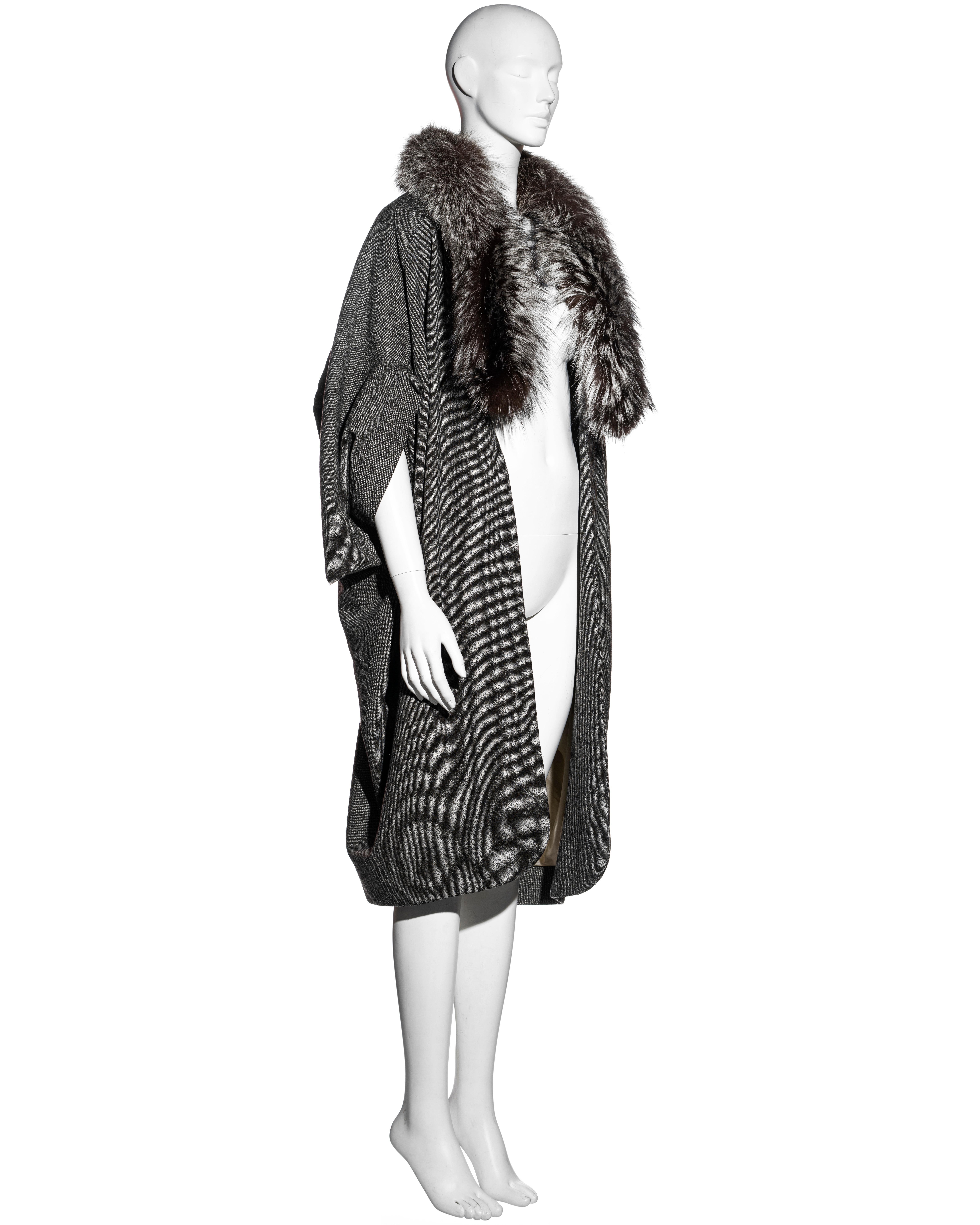 ▪ Christian Dior grey Donegal tweed cocoon coat
▪ Designed by John Galliano 
▪ Fox fur scarf attached to the collar 
▪ Cropped draped sleeves
▪ Open front
▪ Ivory silk lining 
▪ 92% Virgin Wool, 6% Cashmere, 2% Elastane 
▪ FR 36 - UK 8