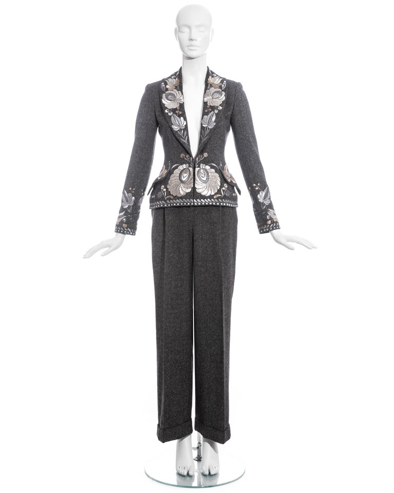 Christian Dior by John Galliano grey Donegal tweed pant suit comprising: fitted blazer jacket with silver metallic embroidery, shawl lapel, silk lining and front hook fastening. High waisted straight leg pants with turn-up hem.

Fall-Winter 1998