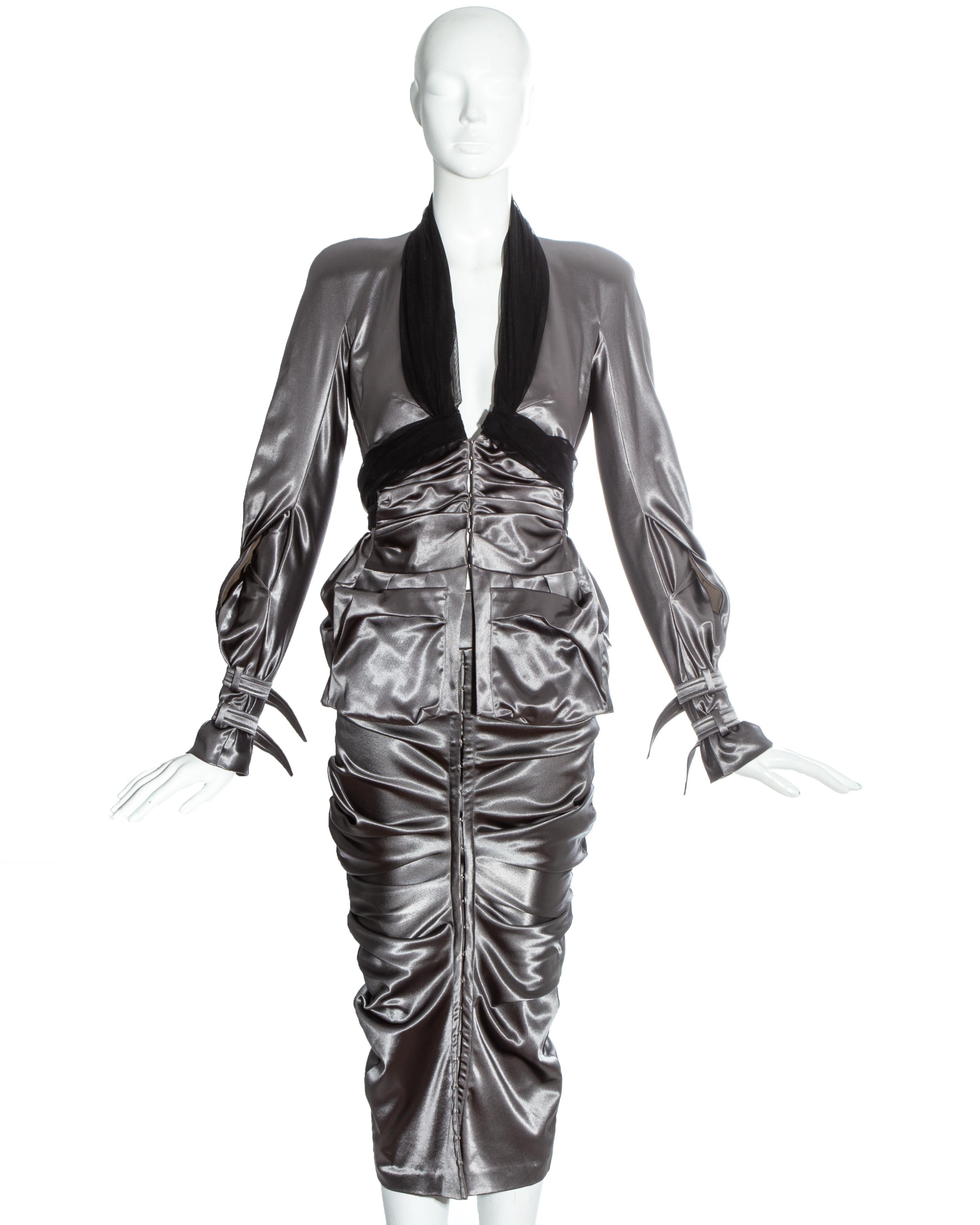 Christian Dior by John Galliano gunmetal grey skirt suit. Ruched jacket with black tulle halter neck, buckled cuffs, twisted sleeves, padded shoulders and corset style metal hook fastenings. Fitted skirt with ruching around hips and matching metal
