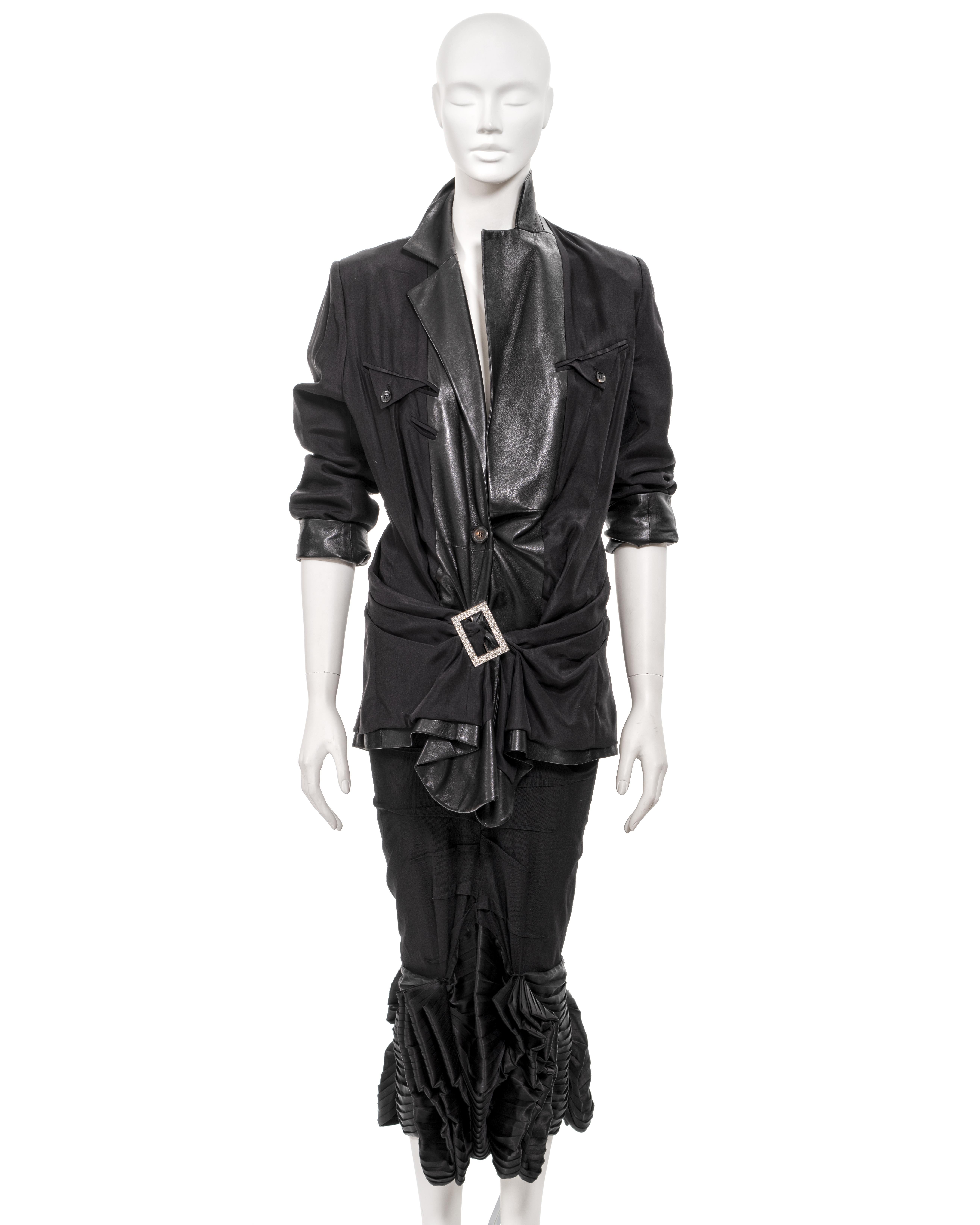 ▪ Christian Dior skirt suit
▪ Creative Director: John Galliano
▪ Spring-Summer 2003 
▪ Inside-out leather jacket with external lining and pockets
▪ Silver buckle adorned with crystals gathers fabric around the hip 
▪ Offset button produces a front
