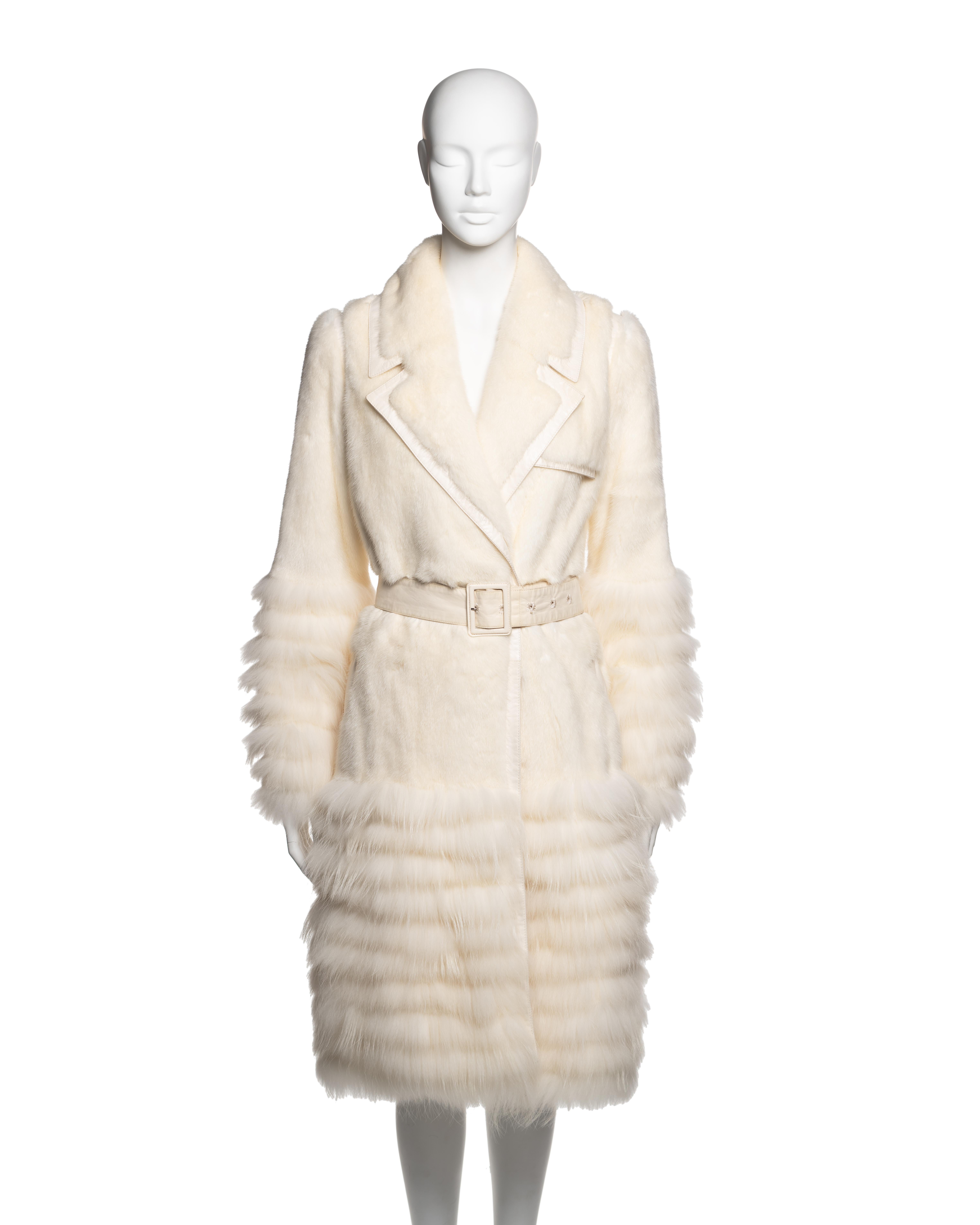 Ivory fur coat designed by John Galliano for Christian Dior, Fall-Winter 2007 collection. The garment is crafted from sheared mink fur with horizontal raccoon fur bands applied to the sleeves and lower skirt. Cut in the style of a classic trench