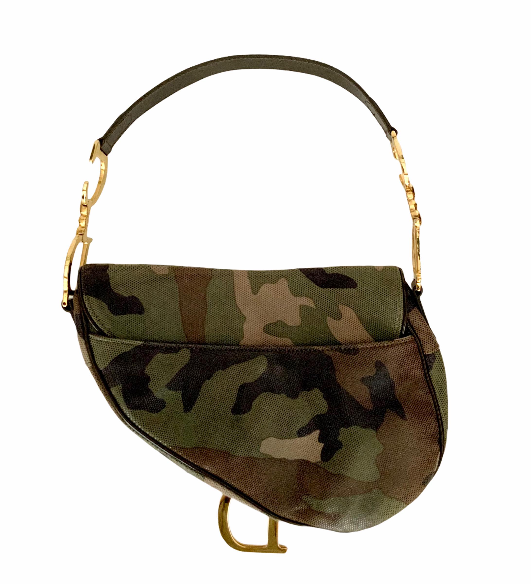 This iconic saddle bag from the house of Christian Dior was designed by John Galliano. 
It is pre-owned but in perfect condition.
It is crafted of shimmering pixelated camouflage leather with patent leather trim.
It features a flat brown patent