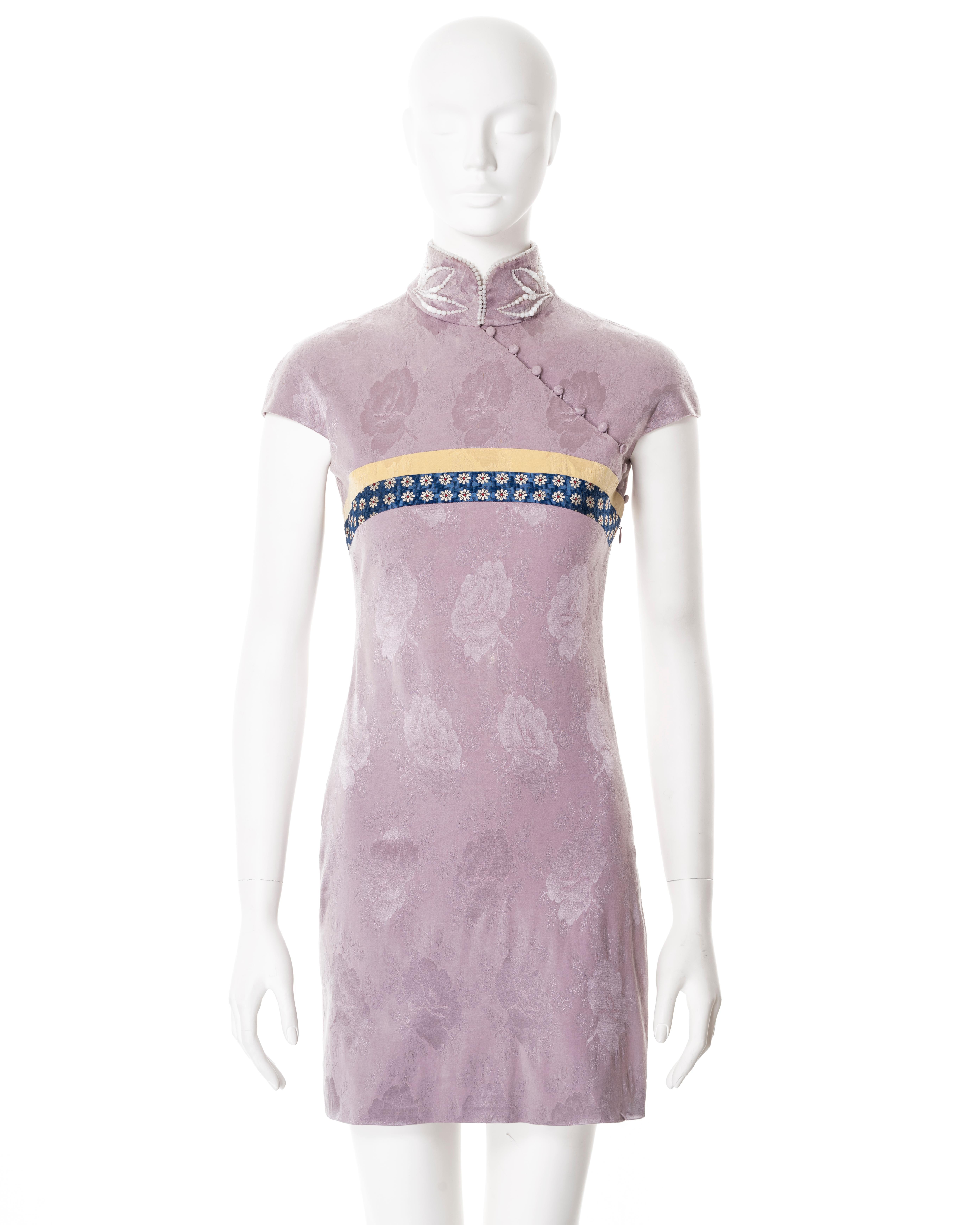 ▪ Christian Dior cheongsam-style mini dress
▪ Creative Director: John Galliano
▪ Sold by One of a Kind Archive
▪ Fall-Winter 1997
▪ Constructed from lilac floral silk damask 
▪ Mandarin collar adorned with faux pearl beads 
▪ Single-sided chest