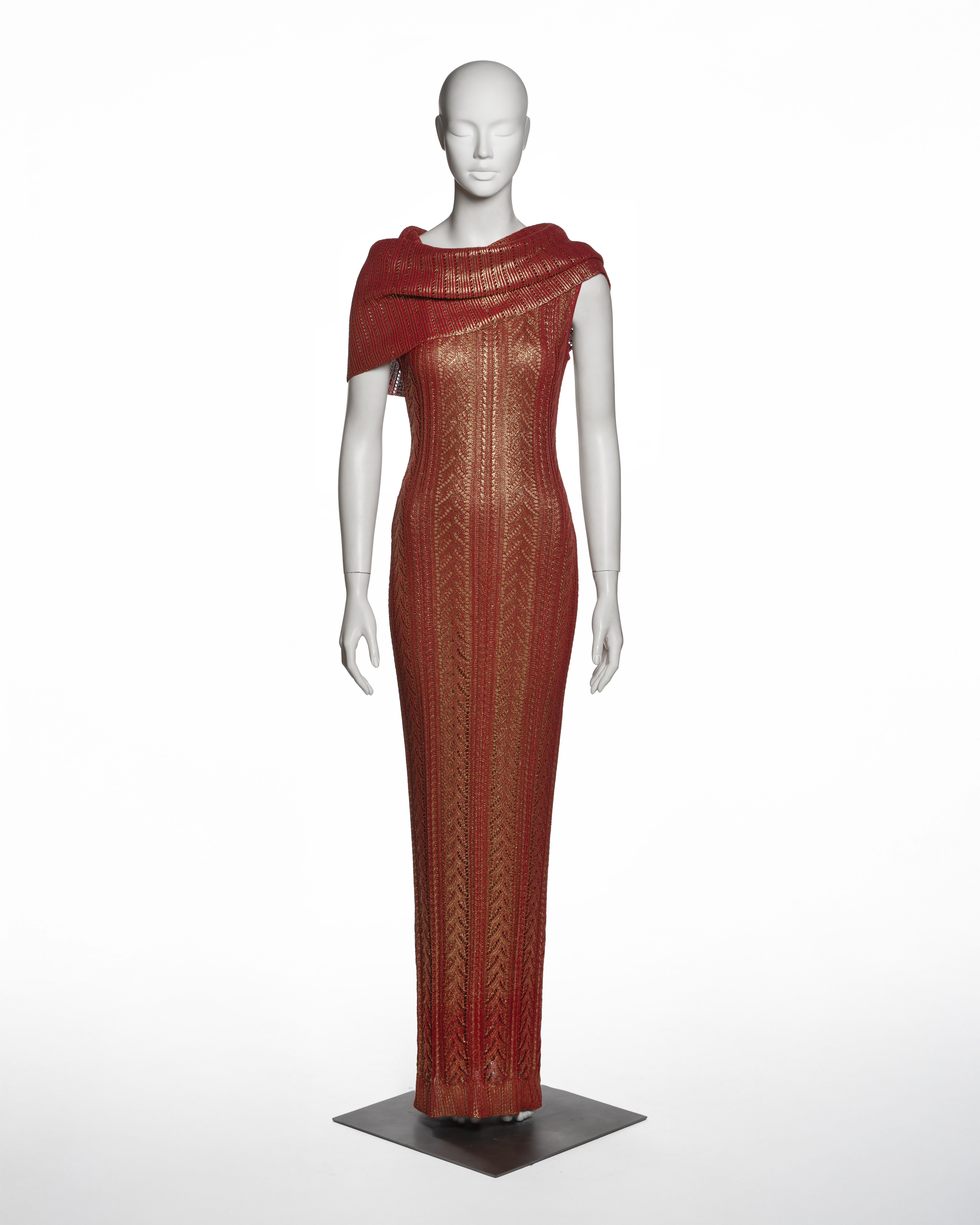 Dieses Abendkleid von Christian Dior by John Galliano aus der Herbst-Winter-Kollektion 1999 ist aus metallisch roter Viskose über einem metallisch goldenen Grundstoff gestrickt, wodurch ein zweifarbiger Lageneffekt entsteht. Der Körper wird durch