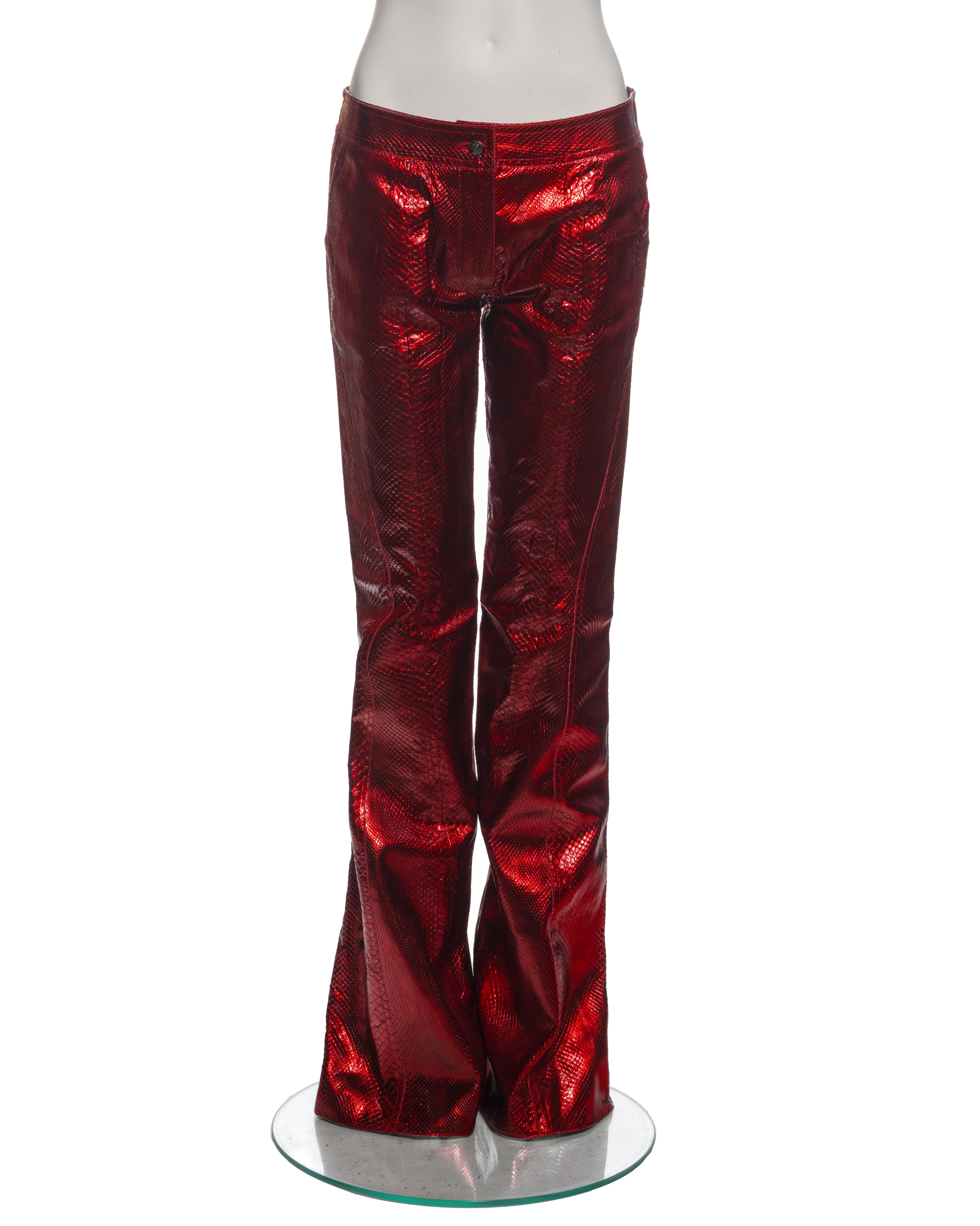 ▪ Archival Christian Dior Flared Trousers
▪ Creative Director: John Galliano
▪ Spring-Summer 2002
▪ Sold by One of a Kind Archive
▪ Crafted from metallic red python leather 
▪ Mid-rise 
▪ Extra long flared cut 
▪ Brand engraved rivet buttons
▪ Red