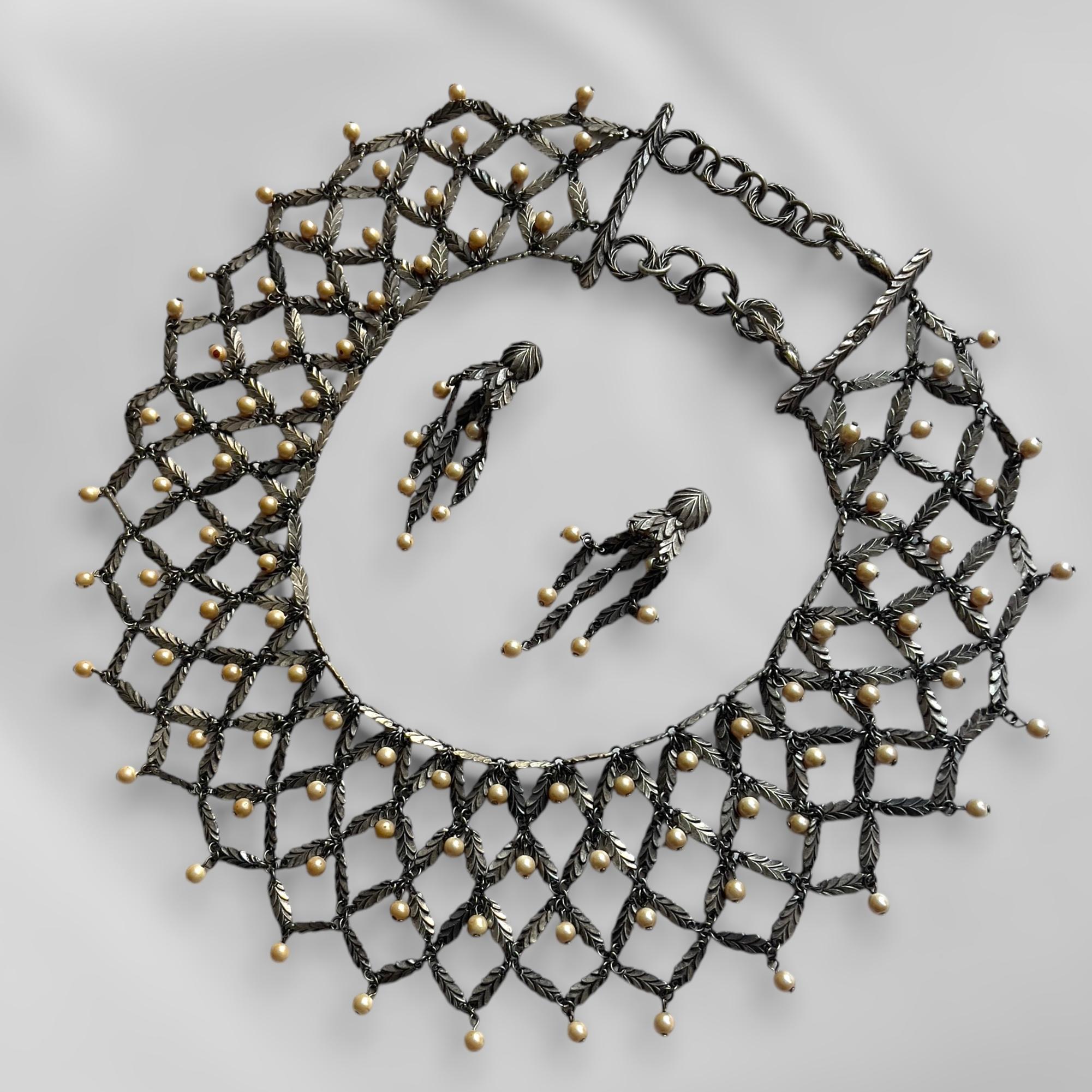 Descrizione del pezzo: Questo raffinato set di gioielli comprende un massiccio girocollo regolabile, orecchini a clip e un braccialetto abbinato, tutti caratterizzati da un delicato design a rete ornato da gocce di perle finte e intricati motivi a