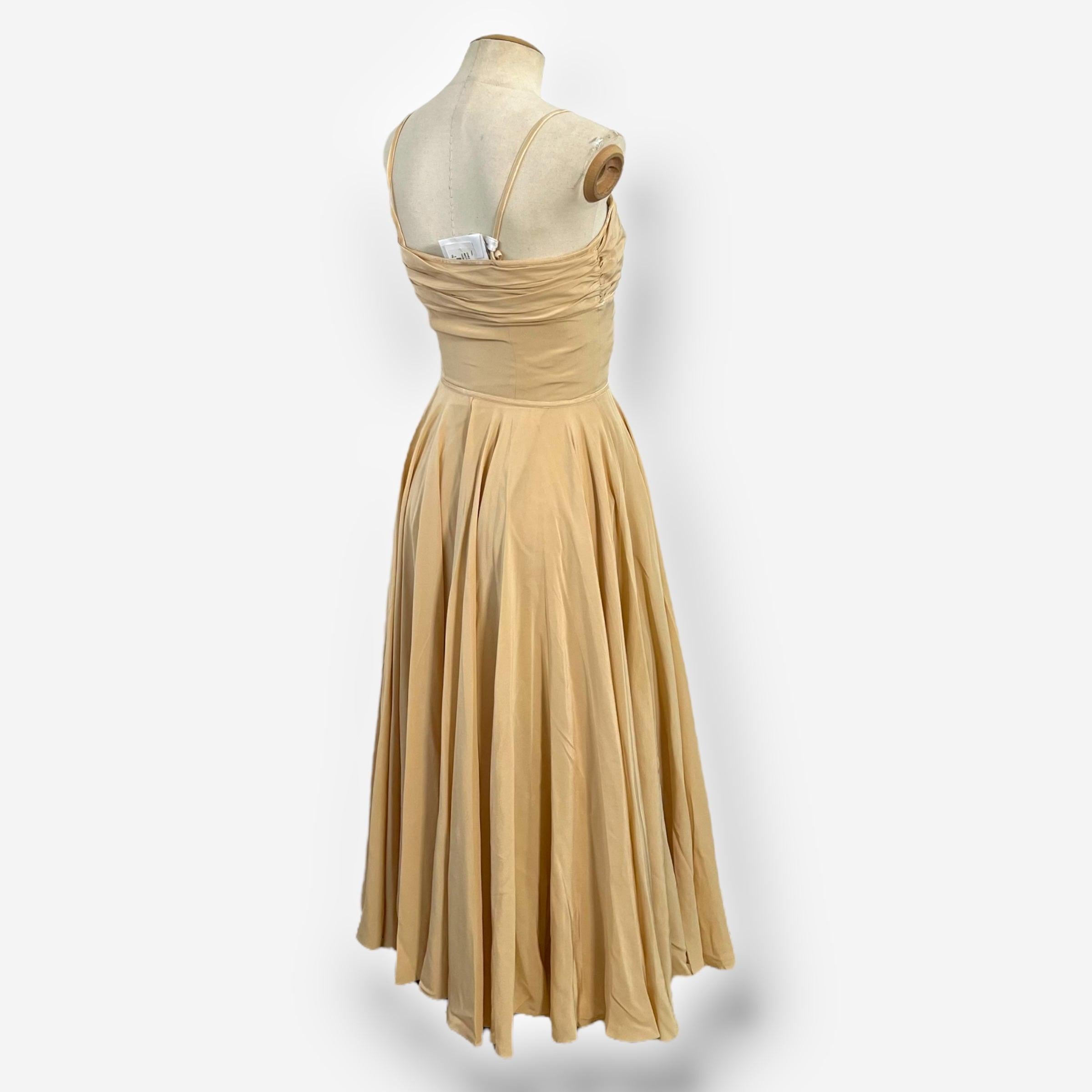Questo romantico abito in seta color nude della collezione 2006 di Christian Dior sotto la guida di John Galliano cattura la miscela di glamour vintage e femminilità sensuale tipica dello stilista. Il corpetto è caratterizzato da una delicata