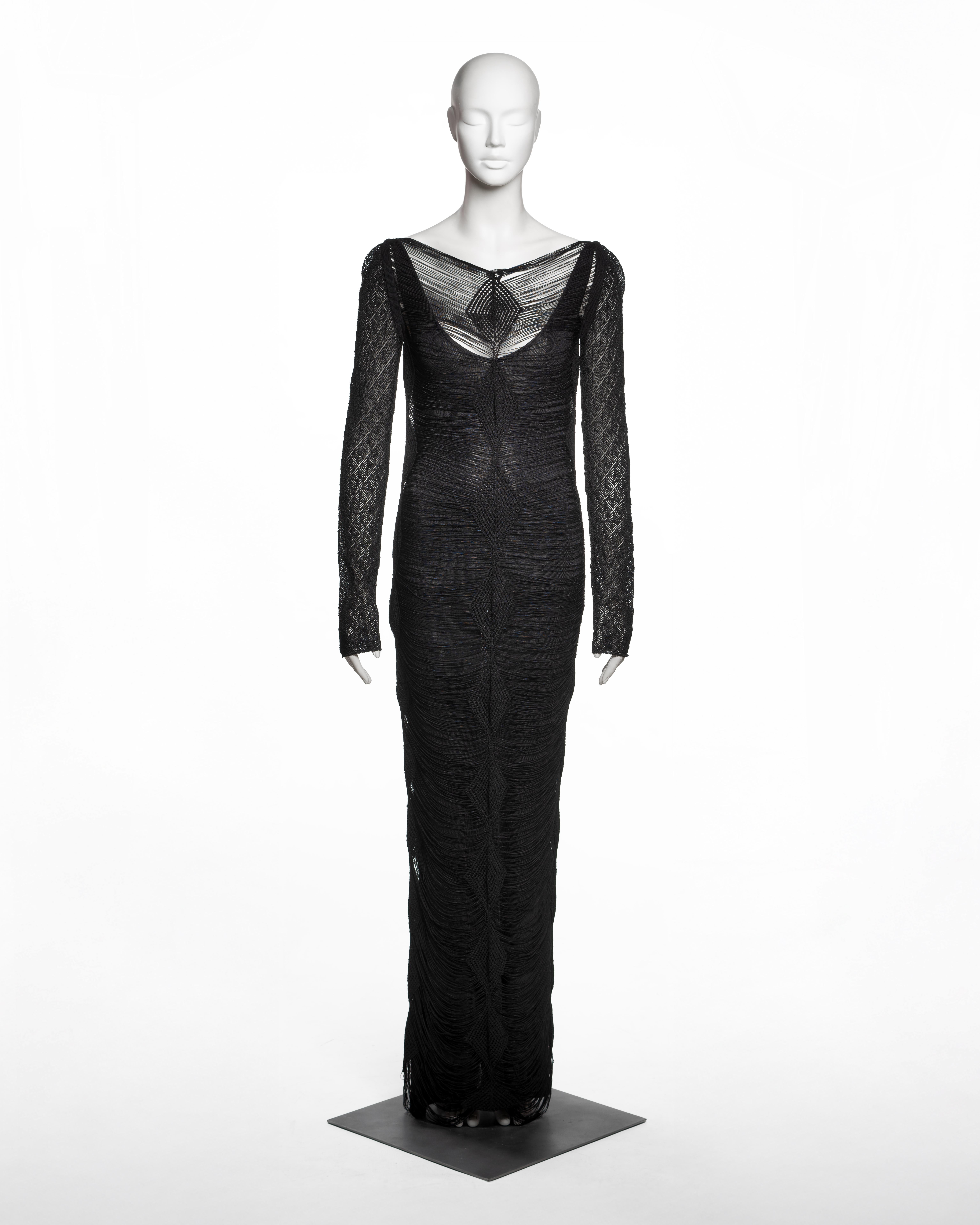 Questo abito da sera di Christian Dior for John Galliano della collezione Primavera-Estate 1999 è realizzato con uno strato esterno di filati di viscosa nera finemente lavorati a maglia, disegnato in una configurazione volutamente aperta con