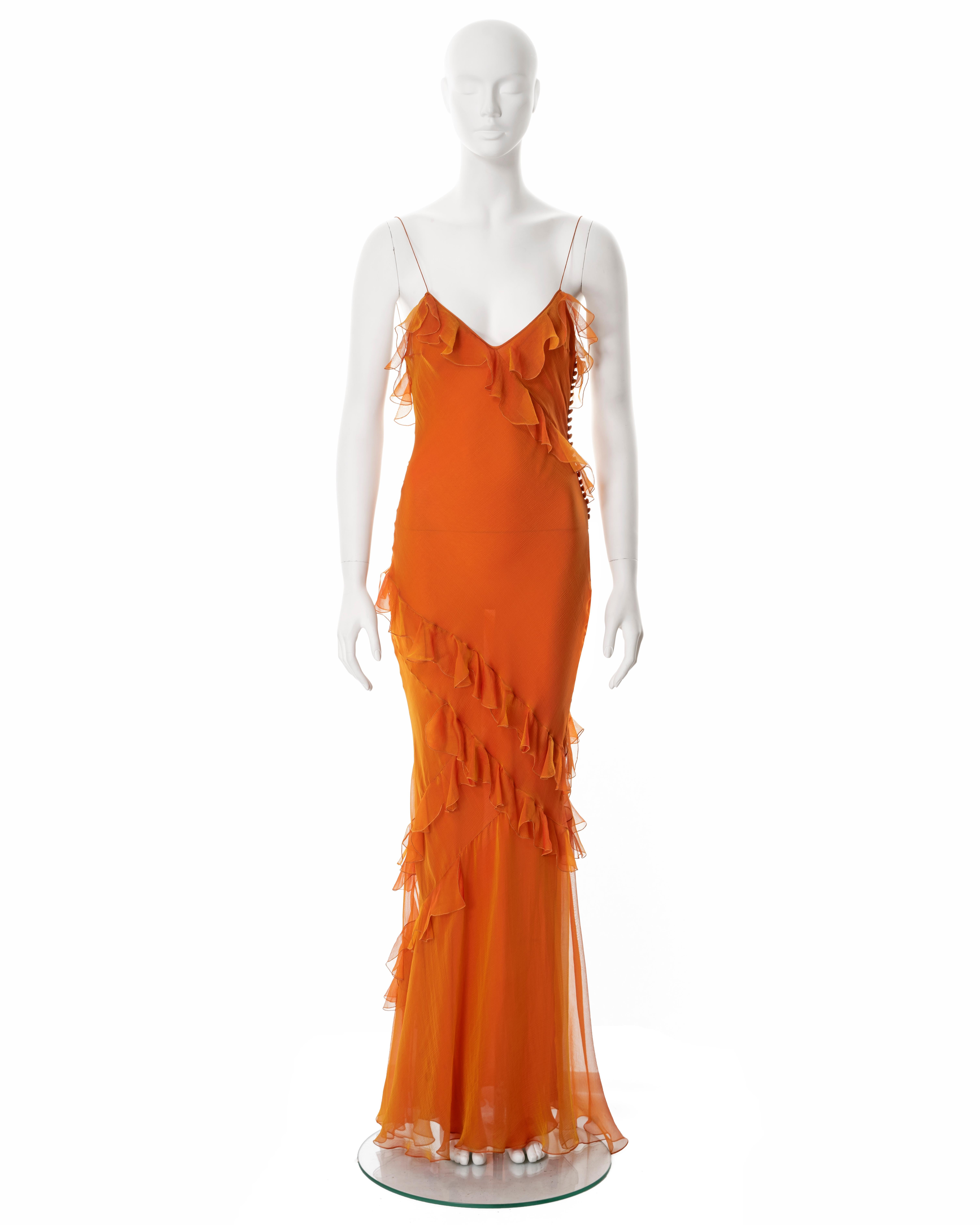 ▪ Christian Dior evening dress
▪ Creative Director: John Galliano
▪ Spring-Summer 2004
▪ Constructed from two-tone orange and yellow bias-cut silk chiffon
▪ Ruffled trim 
▪ Floor-length skirt 
▪ Spaghetti straps
▪ Multiple fabric buttons at the side