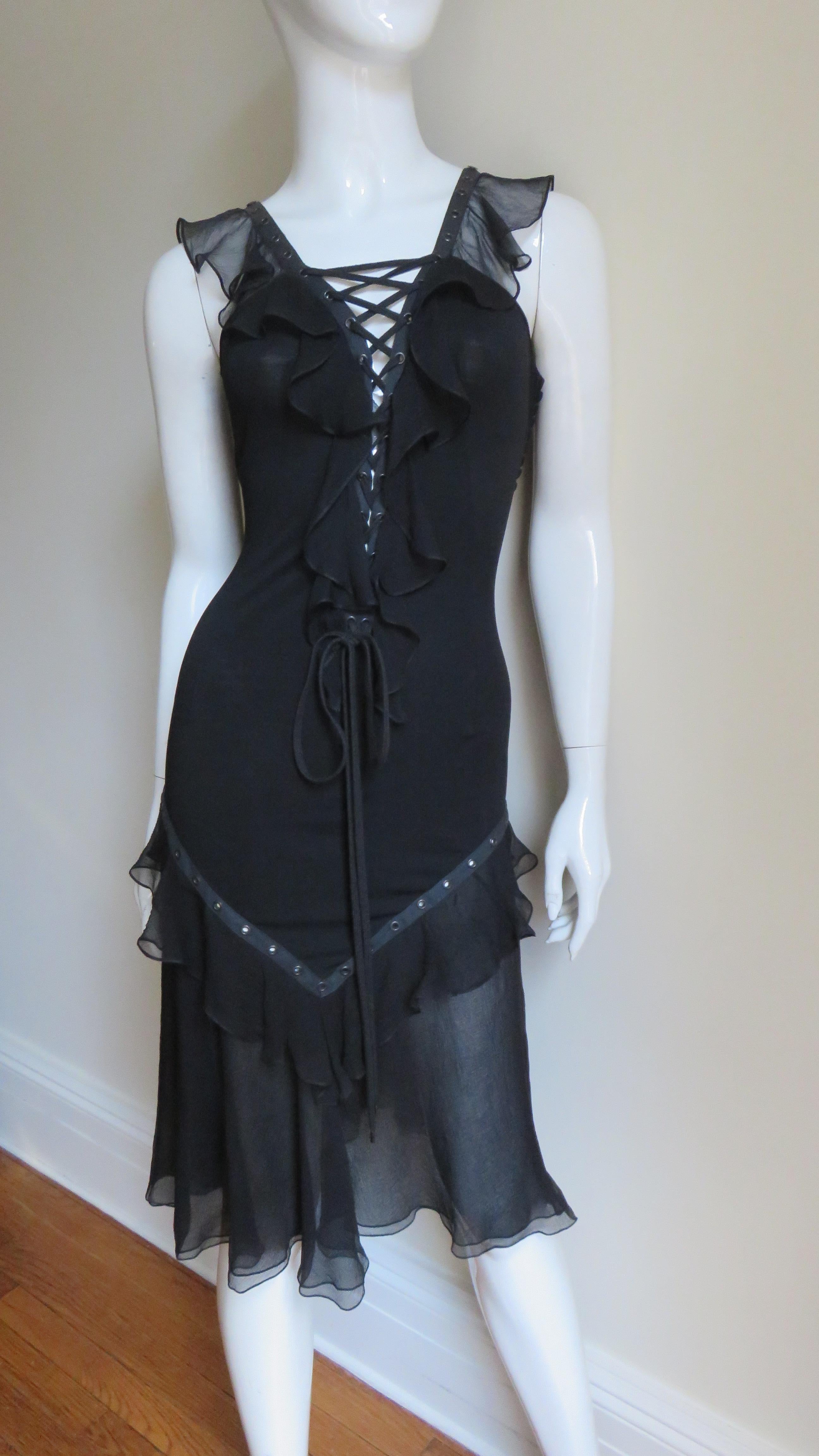 A gorgeous black silk dress by John Galliano for Christian Dior.  The body of the dress is made of fine black stretch silk with functional adjustable lacing at the center front and back from the neckline through to the waist framed in a semi sheer