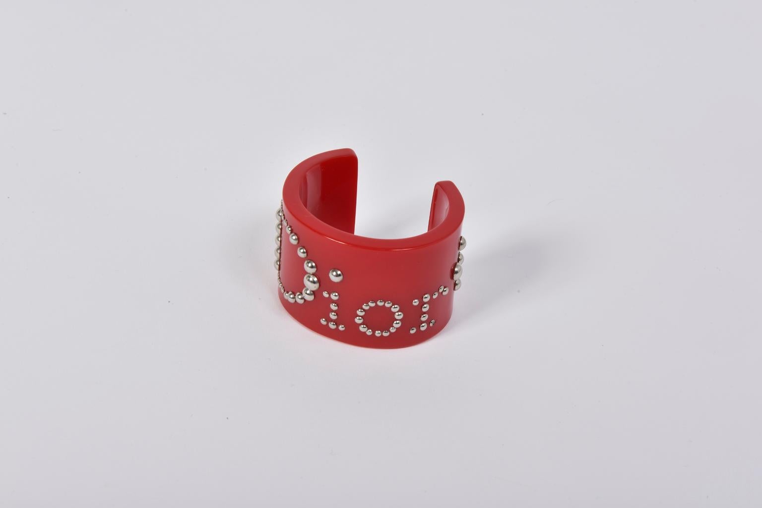 For a color splash, this Christian Dior by John Galliano cuff will do the trick ! Crafted from glossy red resin, it is embellished with silver studs all over, forming the word 
