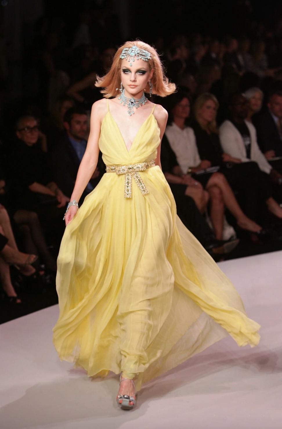 Un pezzo forte di Dior Resort 2008, disegnato da John Galliano durante il suo celebre mandato alla maison. Questo radioso abito giallo sole è realizzato con strati di chiffon di seta plissettato che creano movimento e volume senza sforzo. Il