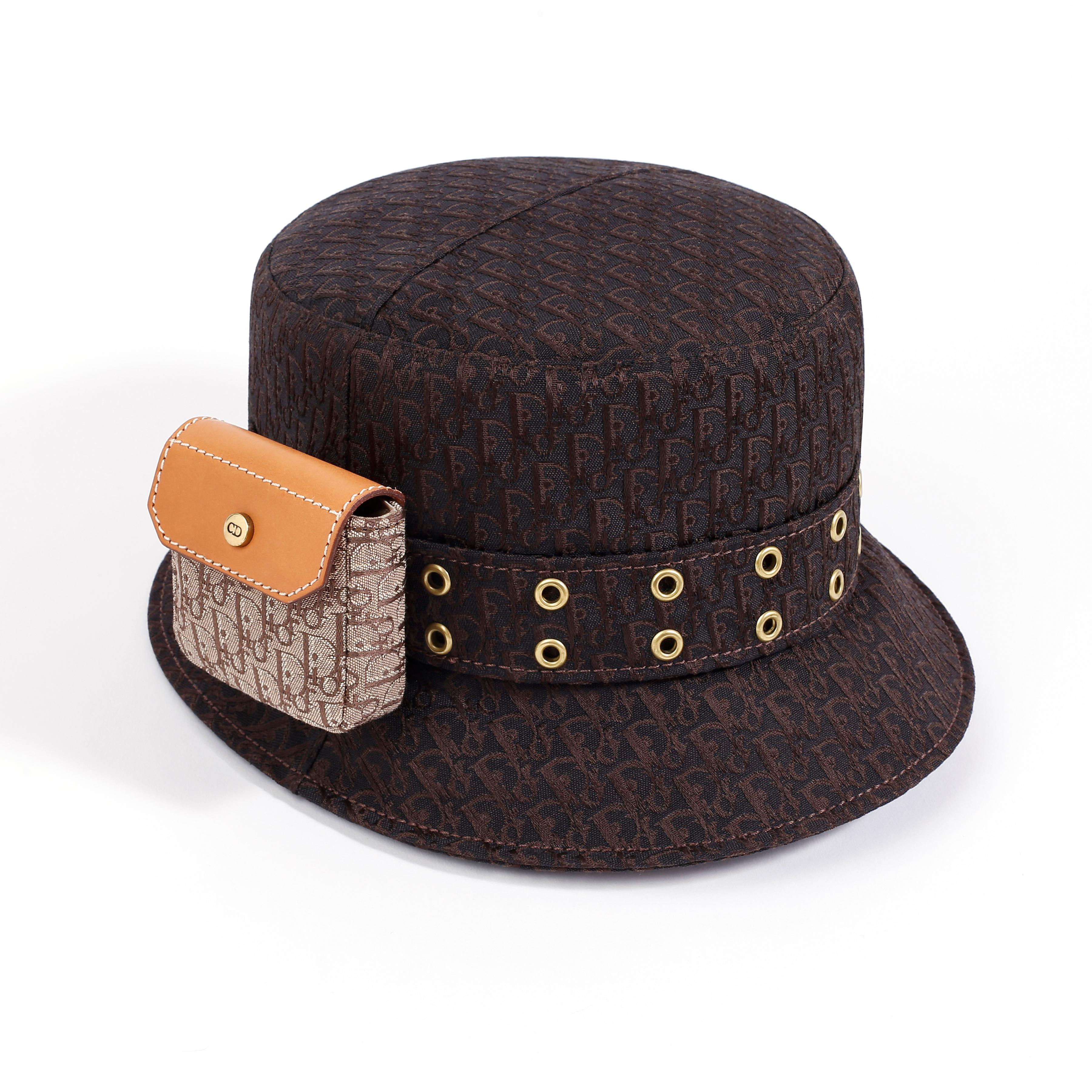 Designed by John Galliano for Christian Dior’s Spring / Summer 2002 collection. Rare style. Contrasting dark brown colored hat with lighter brown/tan pouch. Instantly recognizable “diorissimo” monogram pattern is finely woven and stitched