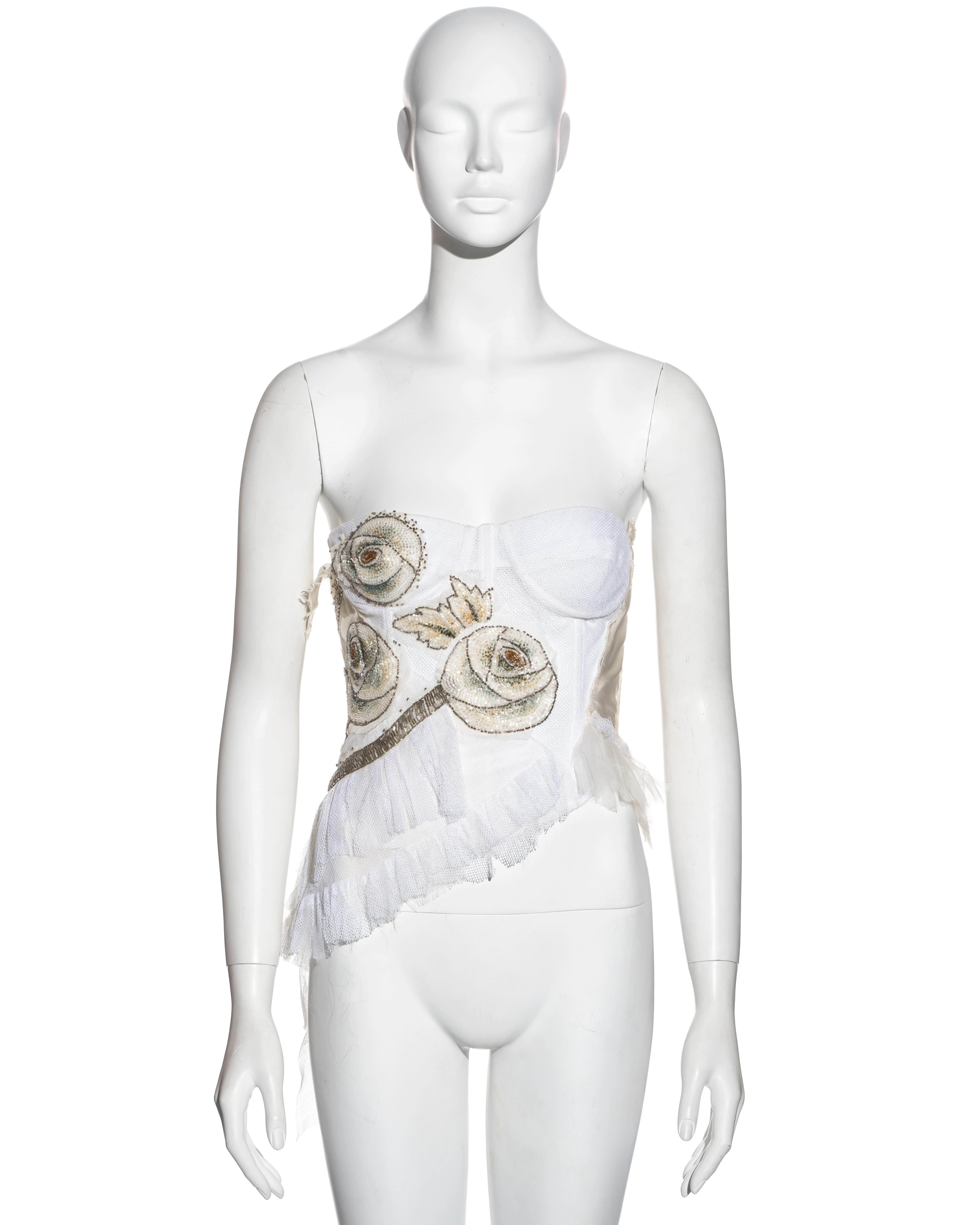 ▪ Rare Christian Dior white corset top 
▪ Designed by John Galliano 
▪ Ivory silk with white cotton tulle overlay 
▪ Floral bugle-beaded embellishments 
▪ Underwire bra 
▪ Ruffled trim with frayed edge 
▪ Metal zipper with Dior 'D' zip pull 
▪ Wrap