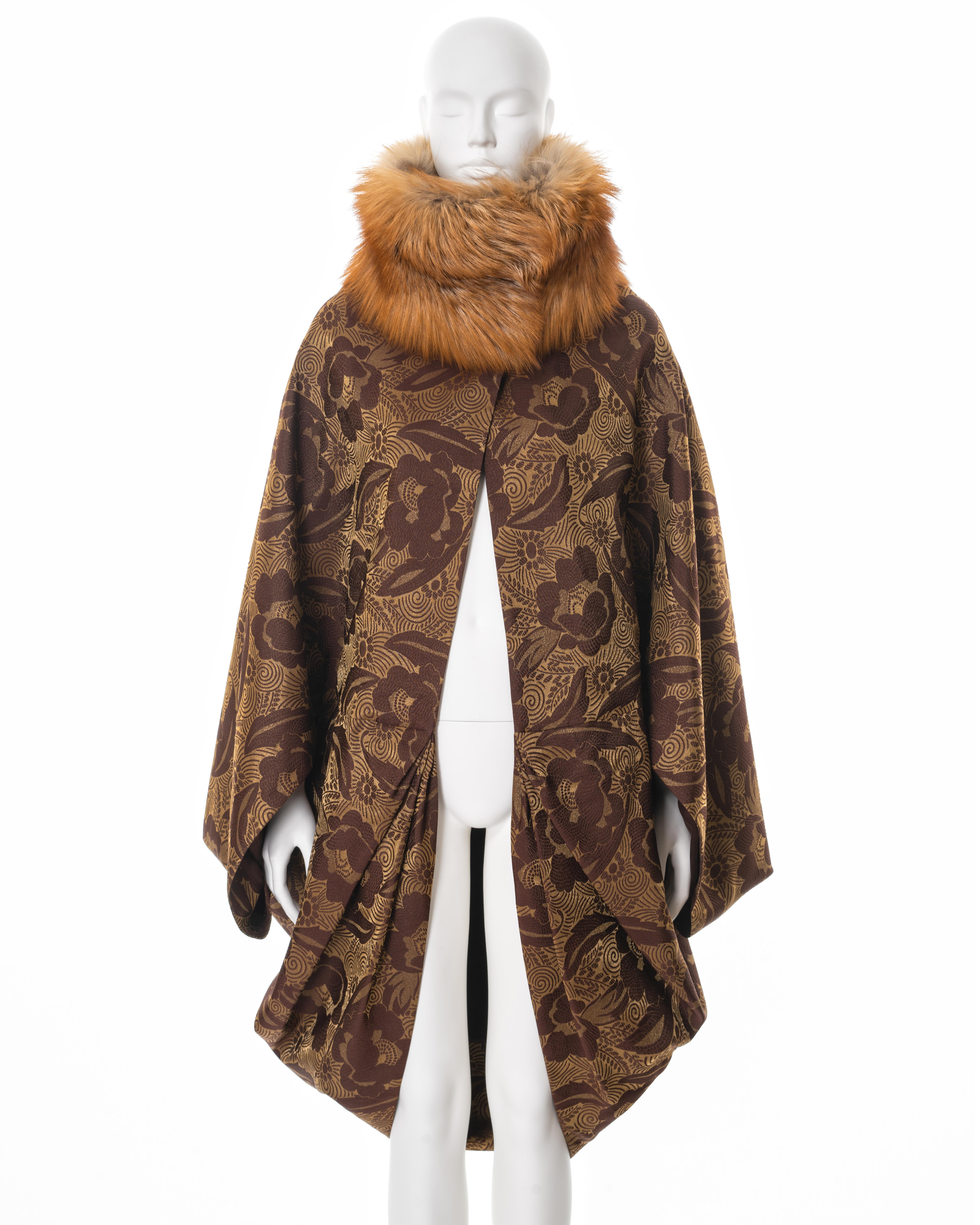 ▪ Christian Dior cocoon coat
▪ Creative Director: John Galliano
▪ Sold by One of a Kind Archive
▪ Spring-Summer 2008
▪ Constructed from brown and gold silk damask 
▪ Fox fur standing collar with invisible hook fastenings 
▪ Brown silk lining 
▪ Can