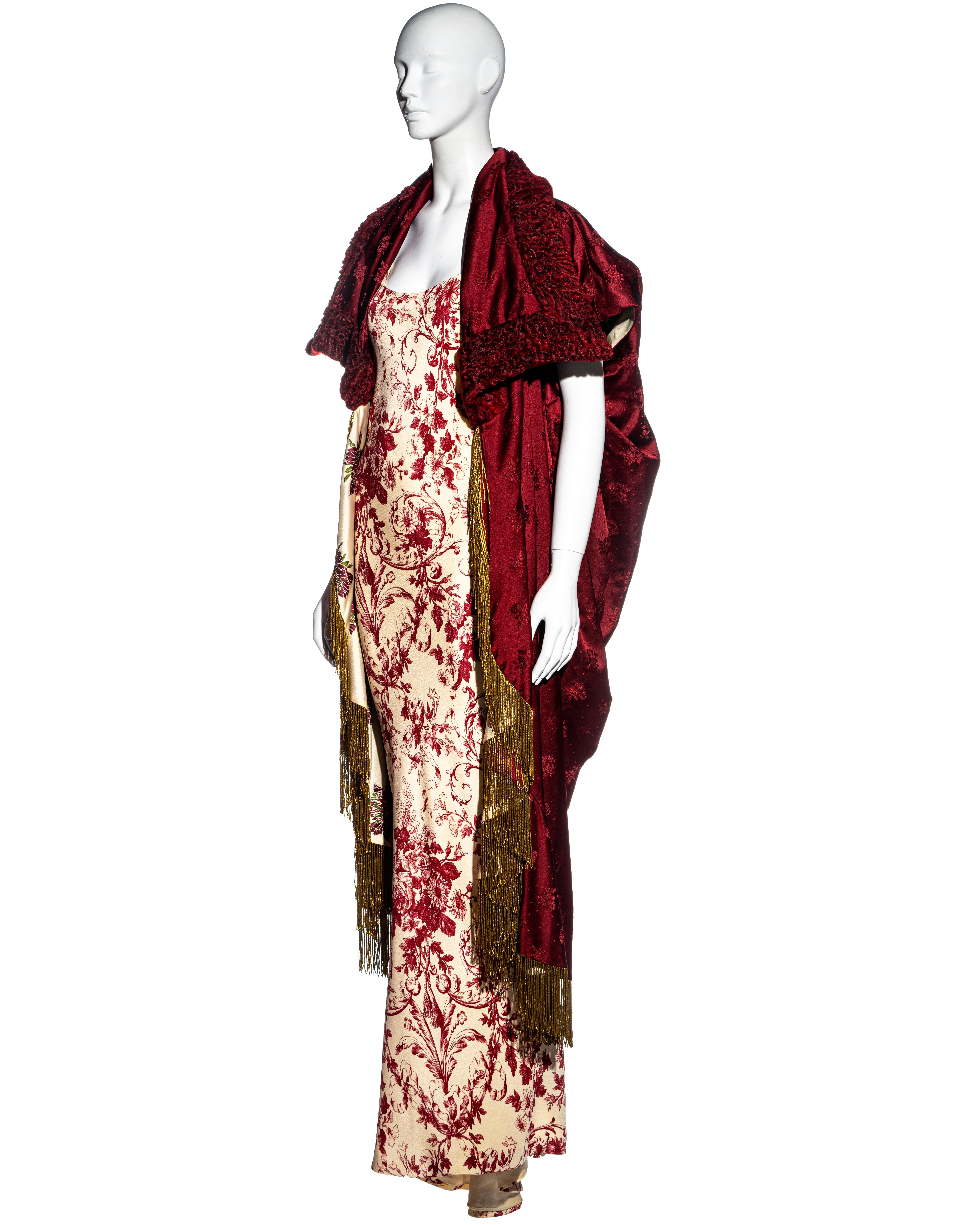 ▪ Christian Dior evening dress and coat set 
▪ Designed by John Galliano 
▪ Red and cream floral printed evening dress with train 
▪ Red silk jacquard reversible cocoon coat 
▪ Persian lamb collar 
▪ Gold metal chain fringes 
▪ FR 40 - UK 12 - IT