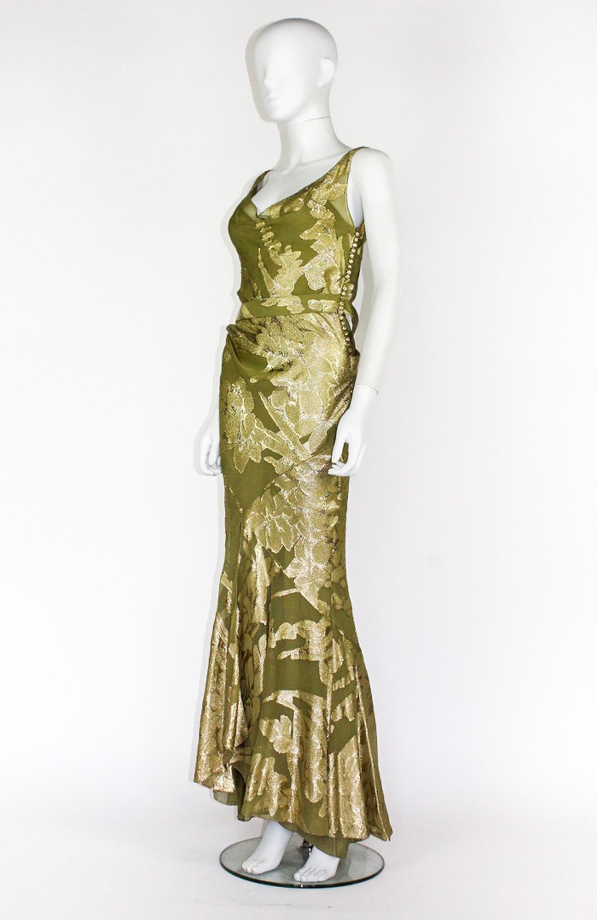 Abito da sera vintage di Christian Dior for John Galliano, della collezione Autunno/Inverno 2004. Seta verde kaki con fili floreali in Lamé metallizzato oro. Cintura in tessuto coordinato che si drappeggia sulla schiena. Chiusura con bottoni in