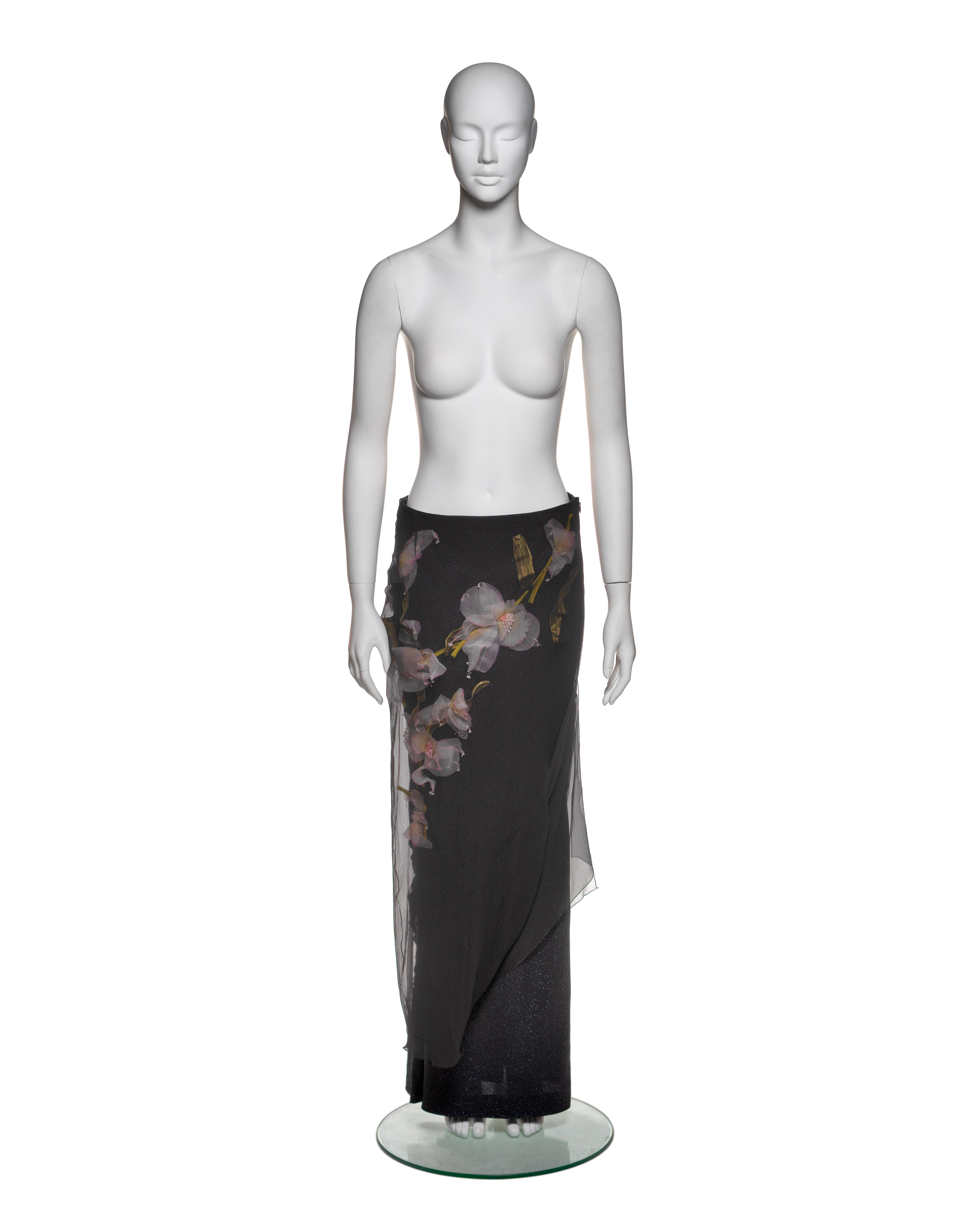 This Christian Dior by John Galliano skirt, from his first ready-to-wear collection for the house, features a black silk chiffon overlay draped over a lurex base. Three-dimensional floral organza appliqués are hand sewn onto the lurex layer beneath