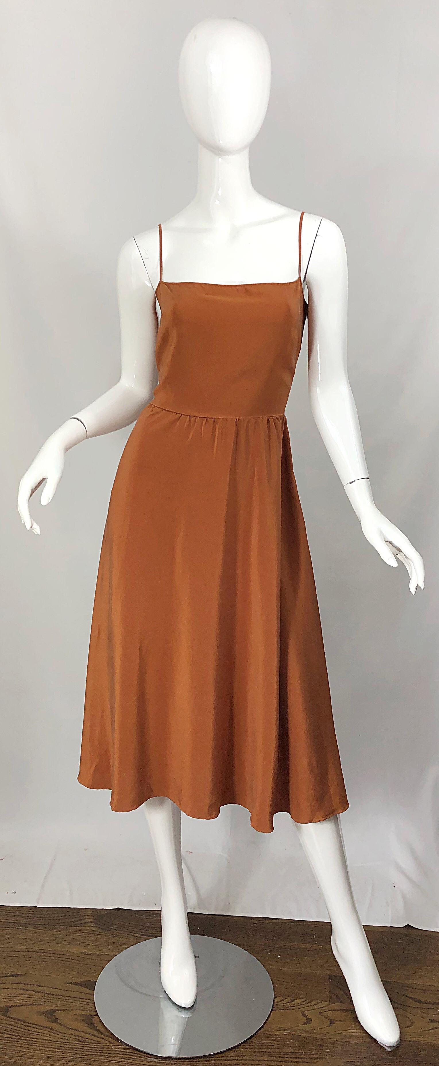 Robe moulante CHRISTIAN DIOR by JOHN GALLIANO fin des années 90 en soie couleur terre cuite ! L'alternative parfaite à la petite robe noire, cette beauté intemporelle sera votre incontournable. Corsage ajusté avec une jupe ample et souple. Fermeture