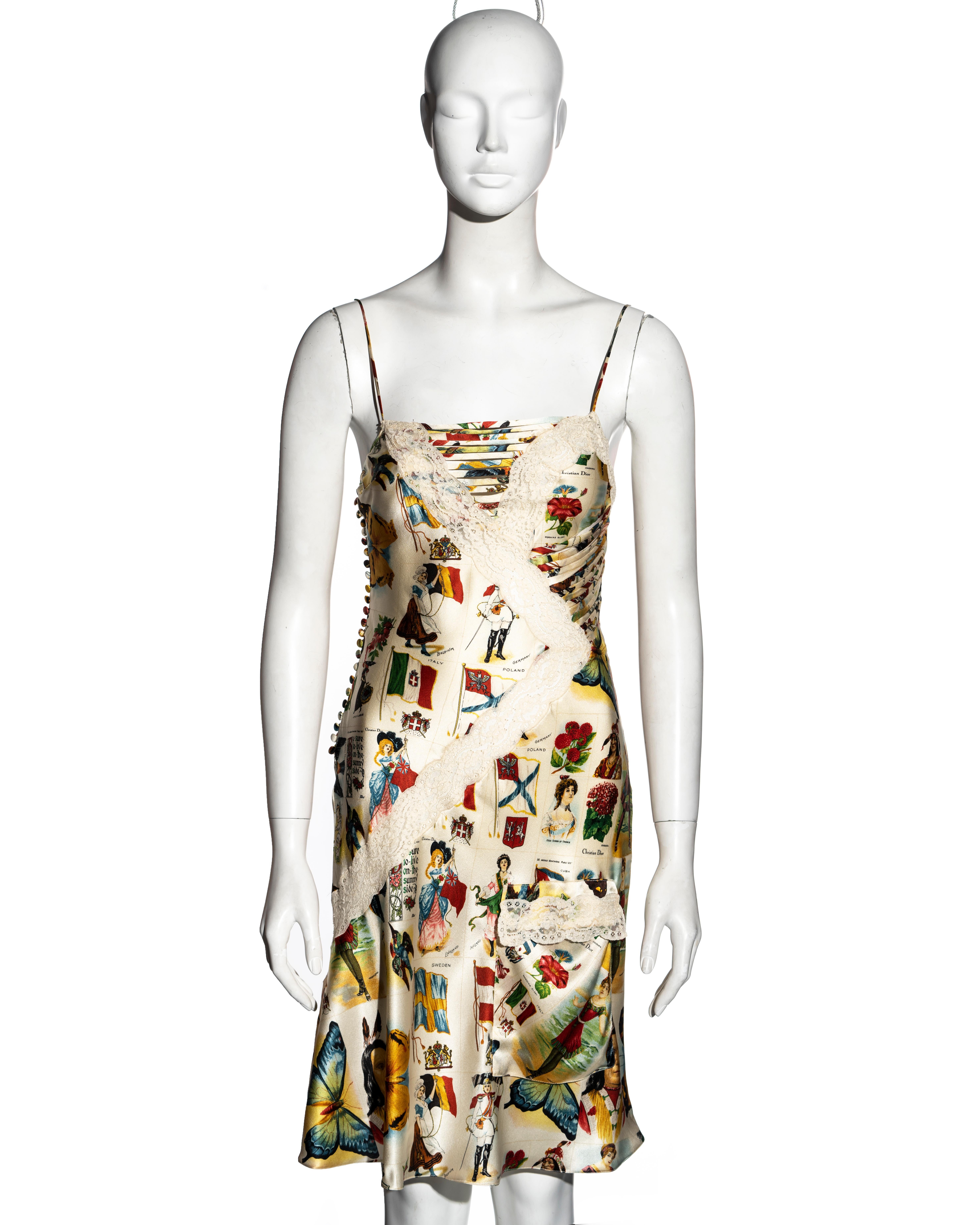 ▪ Christian Dior printed silk slip dress
▪ Designed by John Galliano
▪ Vintage stamp print 
▪ Lace inserts and trim 
▪ Knee-length skirt with two pockets 
▪ Multiple fabric buttons at the side opening 
▪ Spaghetti straps 
▪ FR 38 - UK 10 - US 6
▪