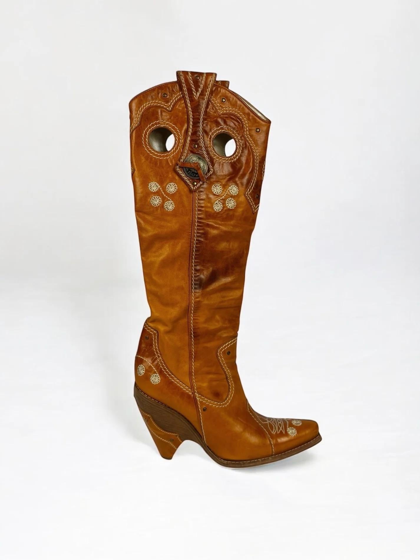 Christian Dior by John Galliano tan leather tall cowboy, 2001
Cream contrast stitching and embroidery
Wooden wedge heel
Intentional weathered leather
Good vintage condition 
With original dust bag (dust bag has some wear)
Size: EUR 38