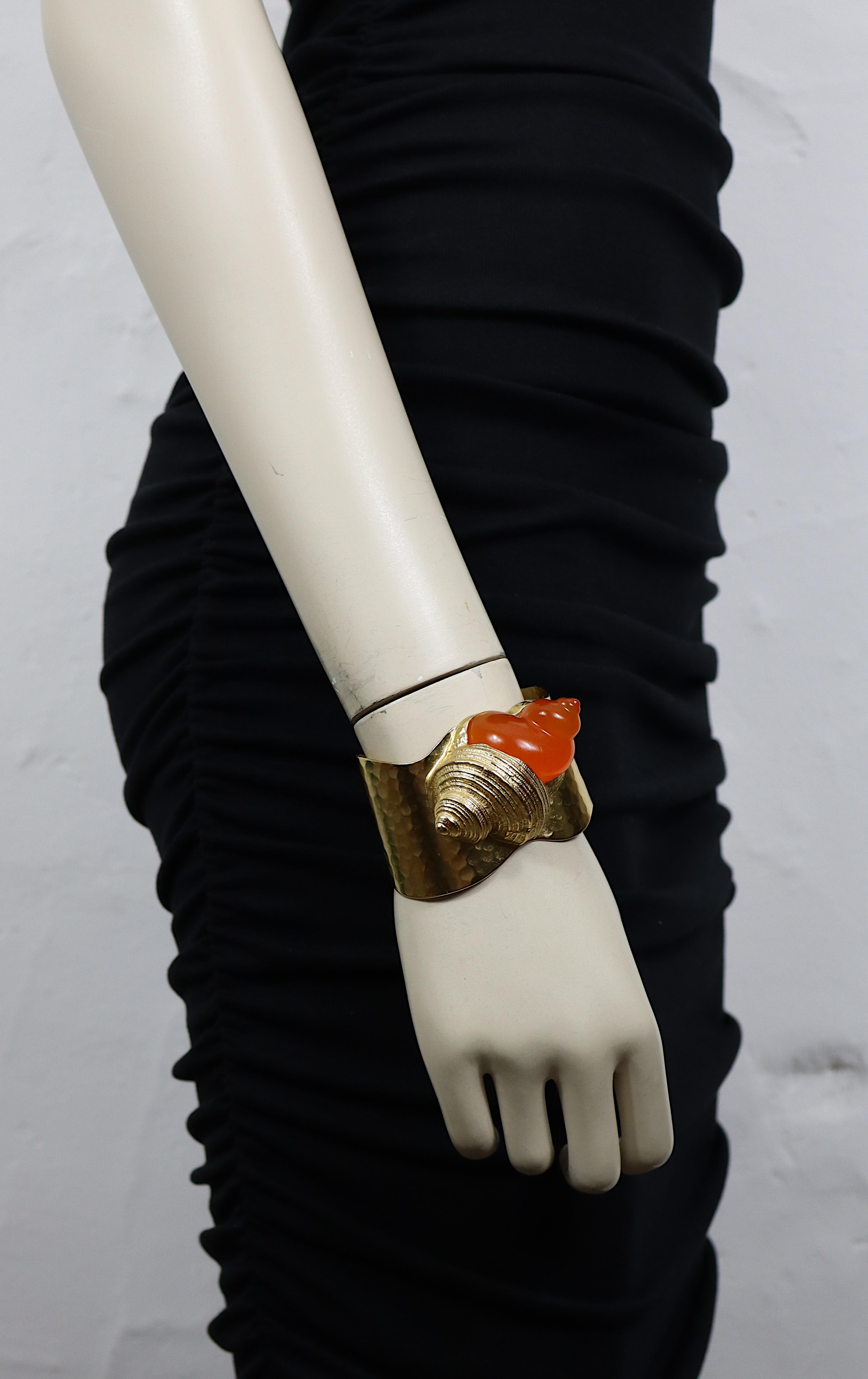 CHRISTIAN DIOR Vintage-Armband mit gehämmerter goldfarbener Manschette und einer großen orangefarbenen Harzschale.

Kreiert von dem französischen Parfümeur ROBERT GOOSSENS für die Lancierung des Duftes DUNE im Jahr 1987.

Geprägtes CHRISTIAN DIOR