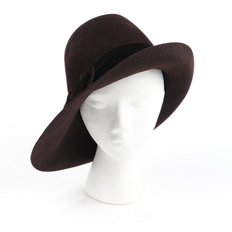 CHRISTIAN DIOR c.2011 Chocolate Brown Felt Velvet Bow Wide Tilted Brim Fedora
 
Brand / Manufacturer: Christian Dior
Collection: c.2011
Designer: John Galliano
Style: Fedora 
Color(s): 
Lined: No
Unmarked Fabric Content: Felt (exterior, interior);