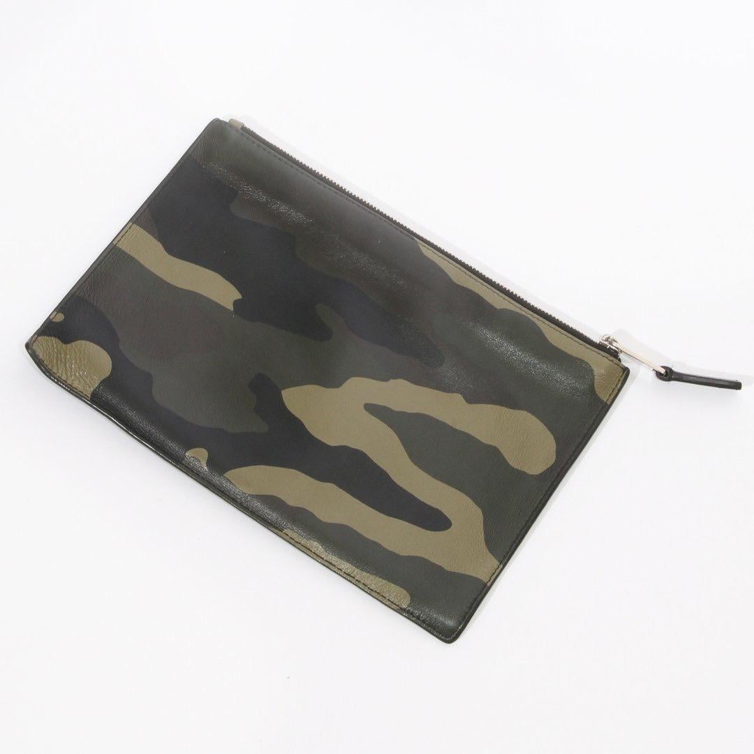 Camo Pouch by Kris Van Assche for Dior Homme
Spring/Summer 2016 
Camo Print Leather with Floral Embroidery  
Rose Motif Patch
Zip Top Closure
“Dior Homme” Logo Embossed at Front 
Nylon Lining
Single Pocket
Condition:  Some slight leatherwear and